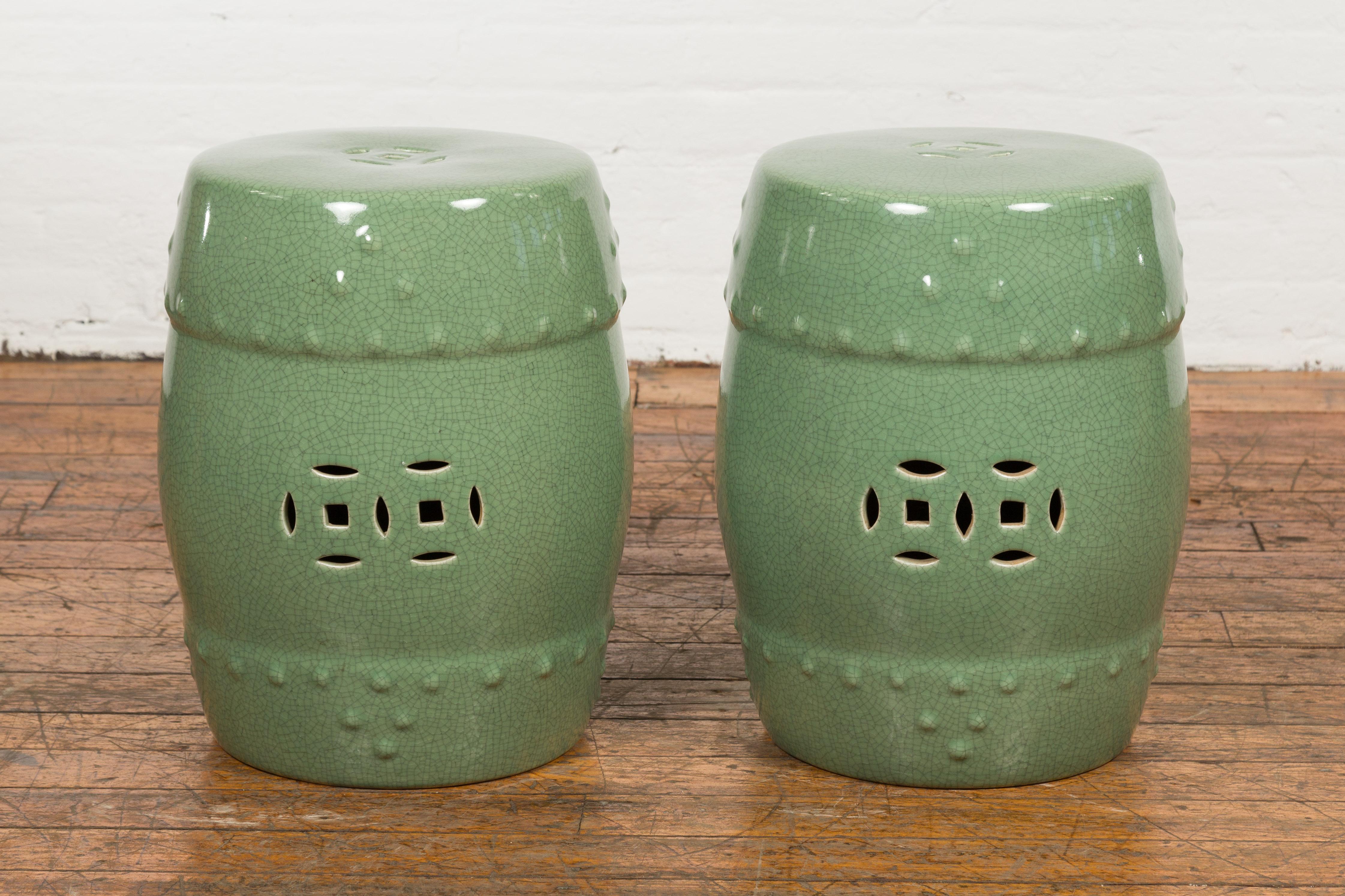 Chinese vintage celadon glazed ceramic garden stool from the Mid-20th Century, with pierced and raised motifs, priced and sold each. Created in China during the mid century period, these elegant garden stools charm us with their celadon glazed