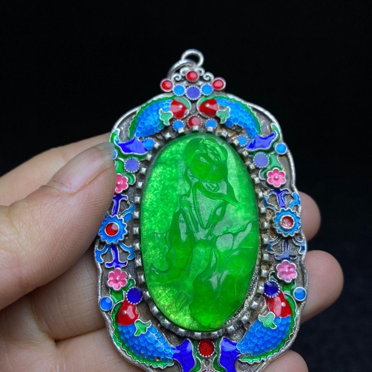 Découvrez la beauté de l'artisanat traditionnel chinois avec ce pendentif Vintage Cloisonné, qui présente une étonnante sculpture de jade vert entourée d'un émail cloisonné complexe orné de motifs de bon augure. Ce pendentif exquis symbolise
