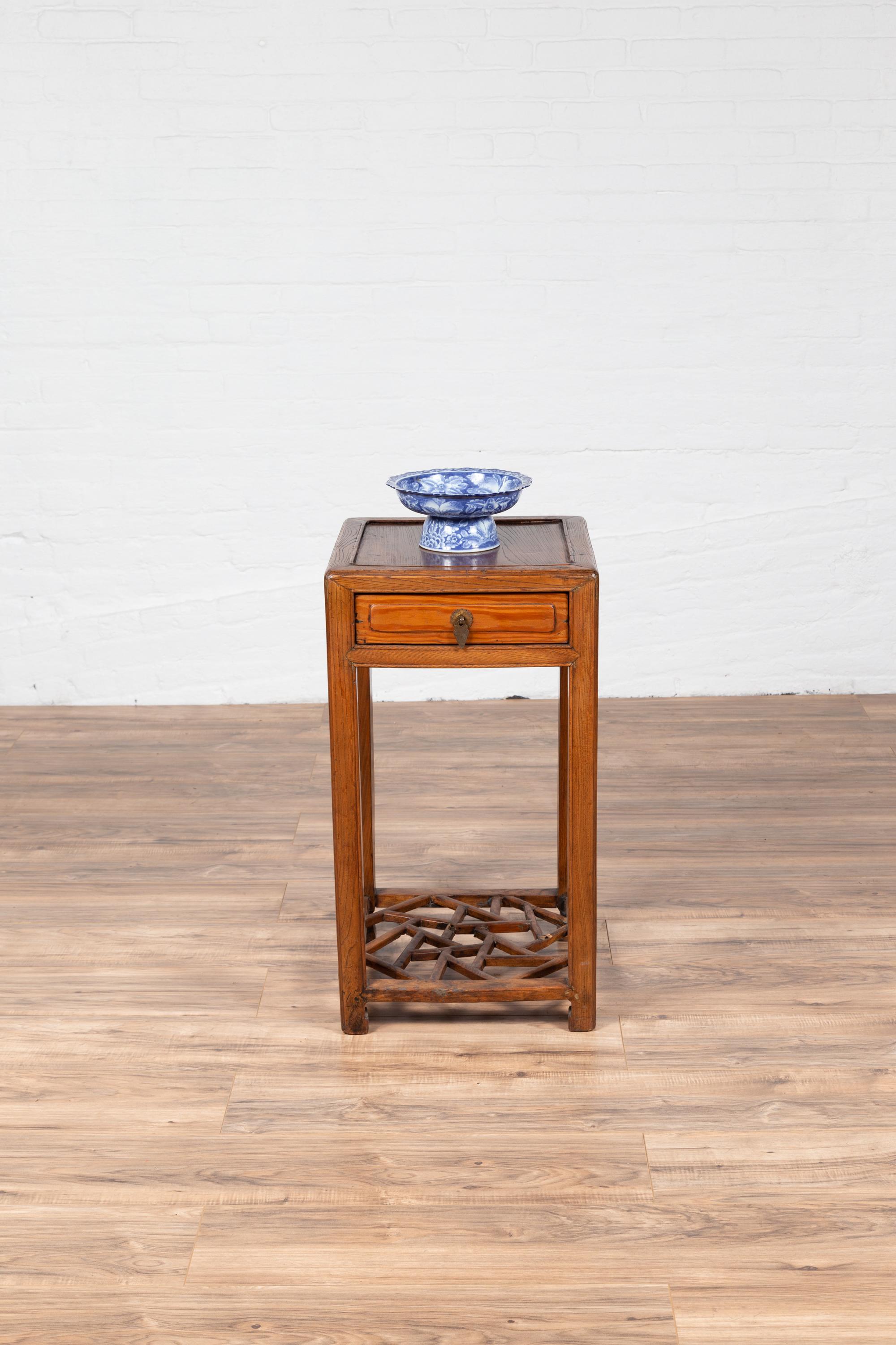 Une table de lampe vintage en bois d'orme du milieu du 20e siècle, avec un seul tiroir et une étagère à glace fissurée. Cette table de lampe vintage en bois d'orme du milieu du 20e siècle dégage un charme et une élégance intemporelle, incarnant la
