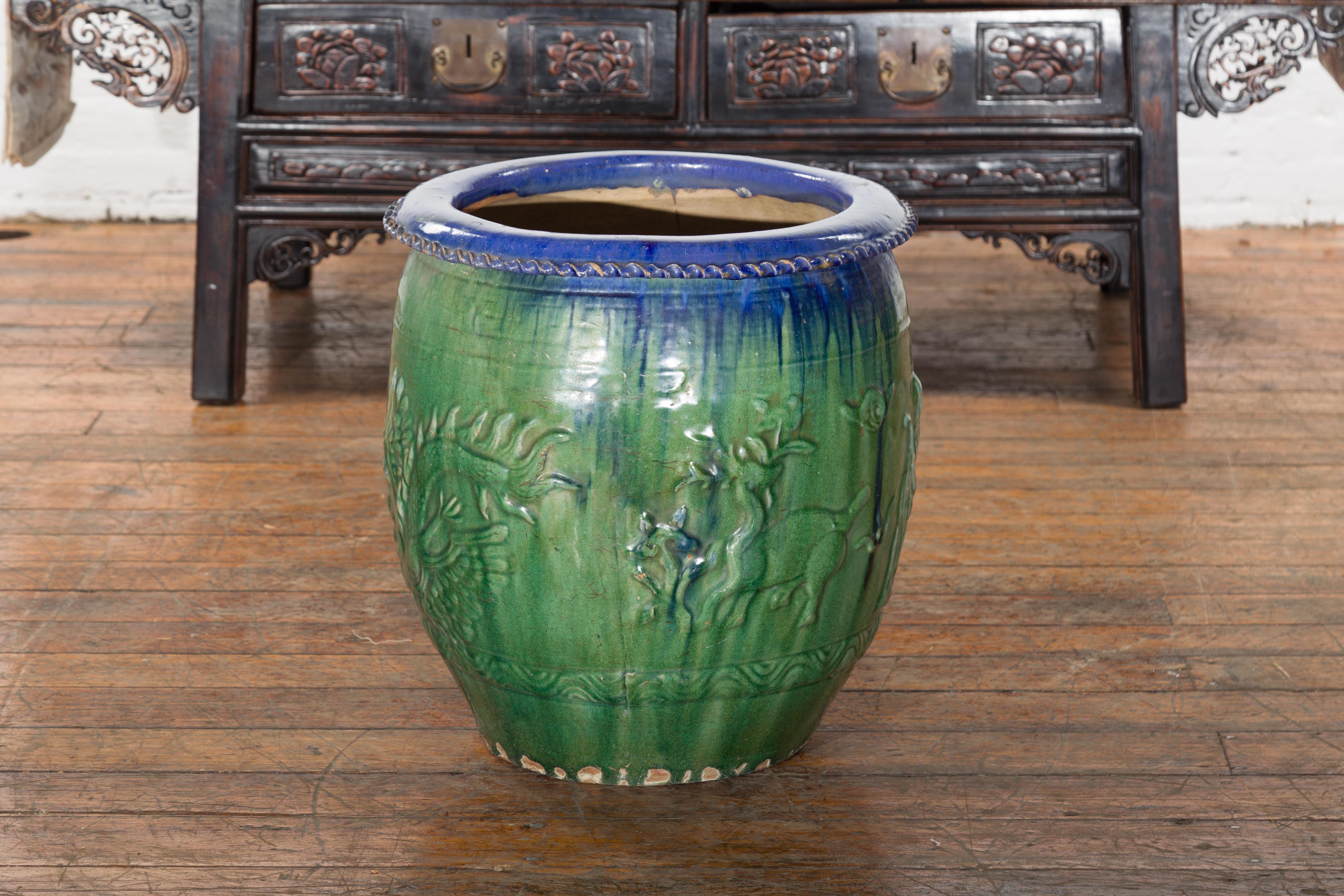 A Chinese vintage blue and green glazed garden planter from the mid 20th century, with raised animal décor. Created in China during the midcentury period, this large garden planter attracts our attention with its green and blue glazed body. Adorned