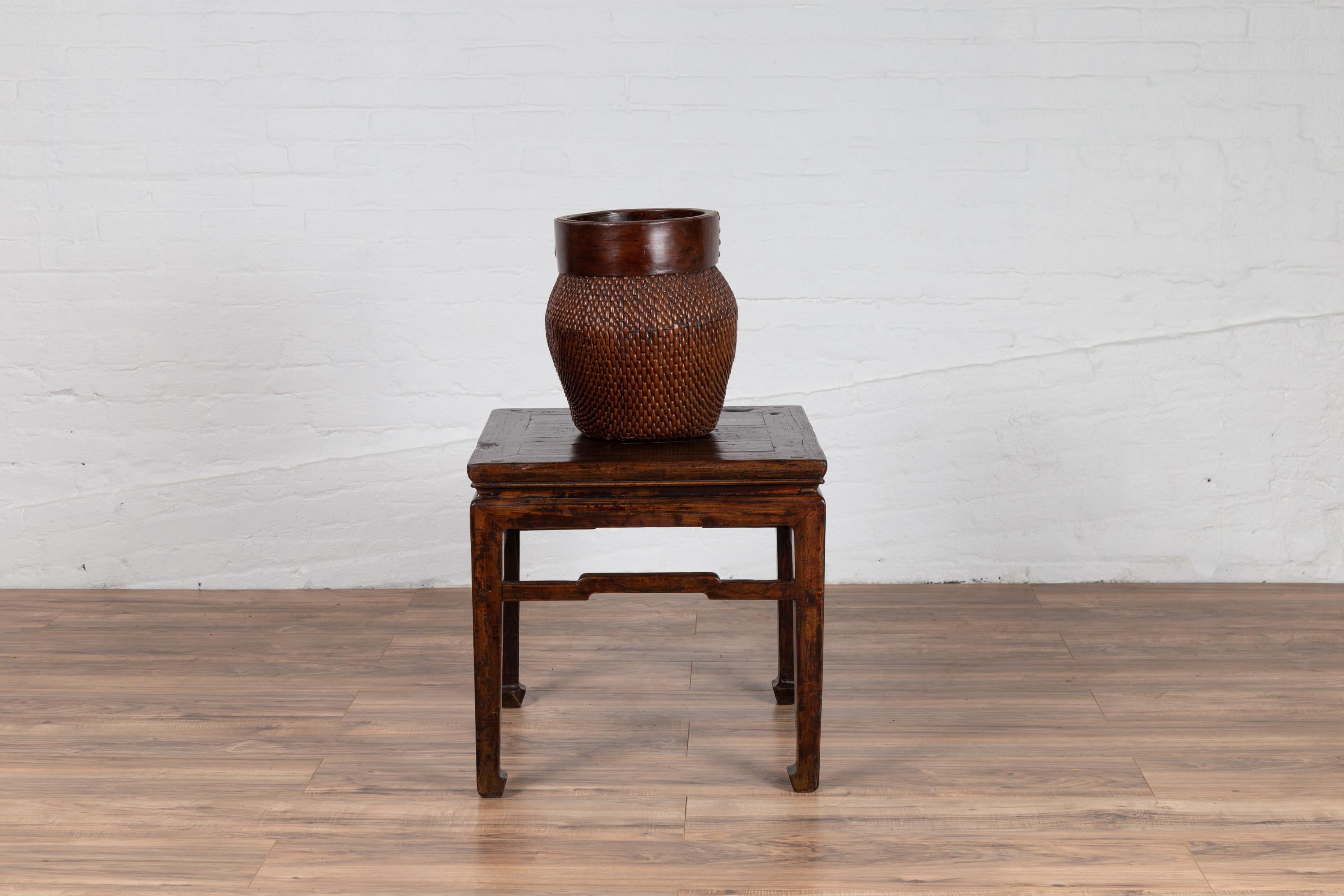 Chinese vintage Ming Dynasty style side table from the mid-20th century, with dark patina, horse hoofed feet and humpback side stretchers. Born in China during the mid-century period, this elegant Ming Dynasty table features a square top, sitting