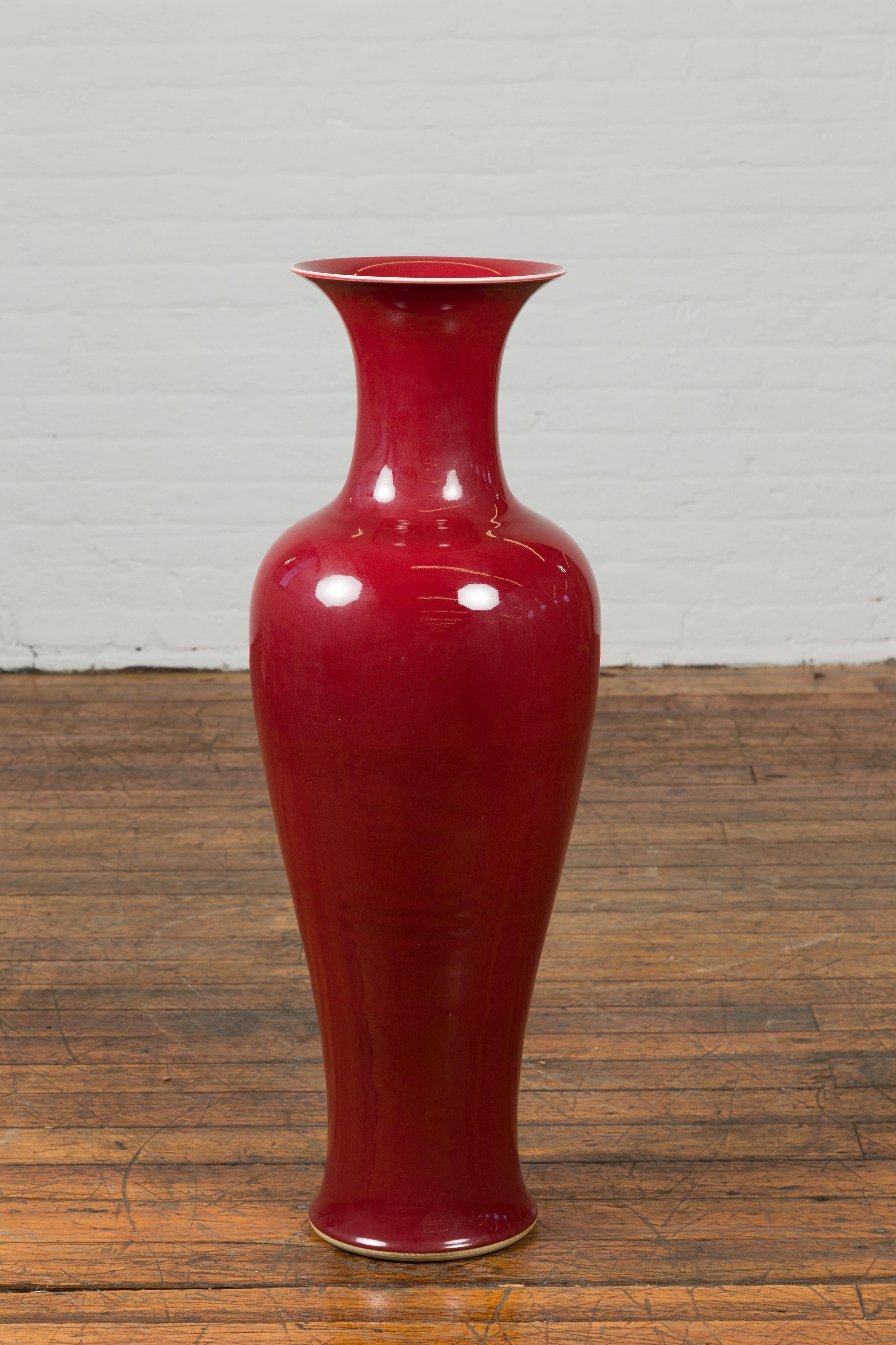 A Chinese vintage oxblood altar vase from the mid-20th century, with flaring neck. We currently have several available, priced and sold $1,300 each. Created in China during the midcentury period, this altar vase attracts our attention with its