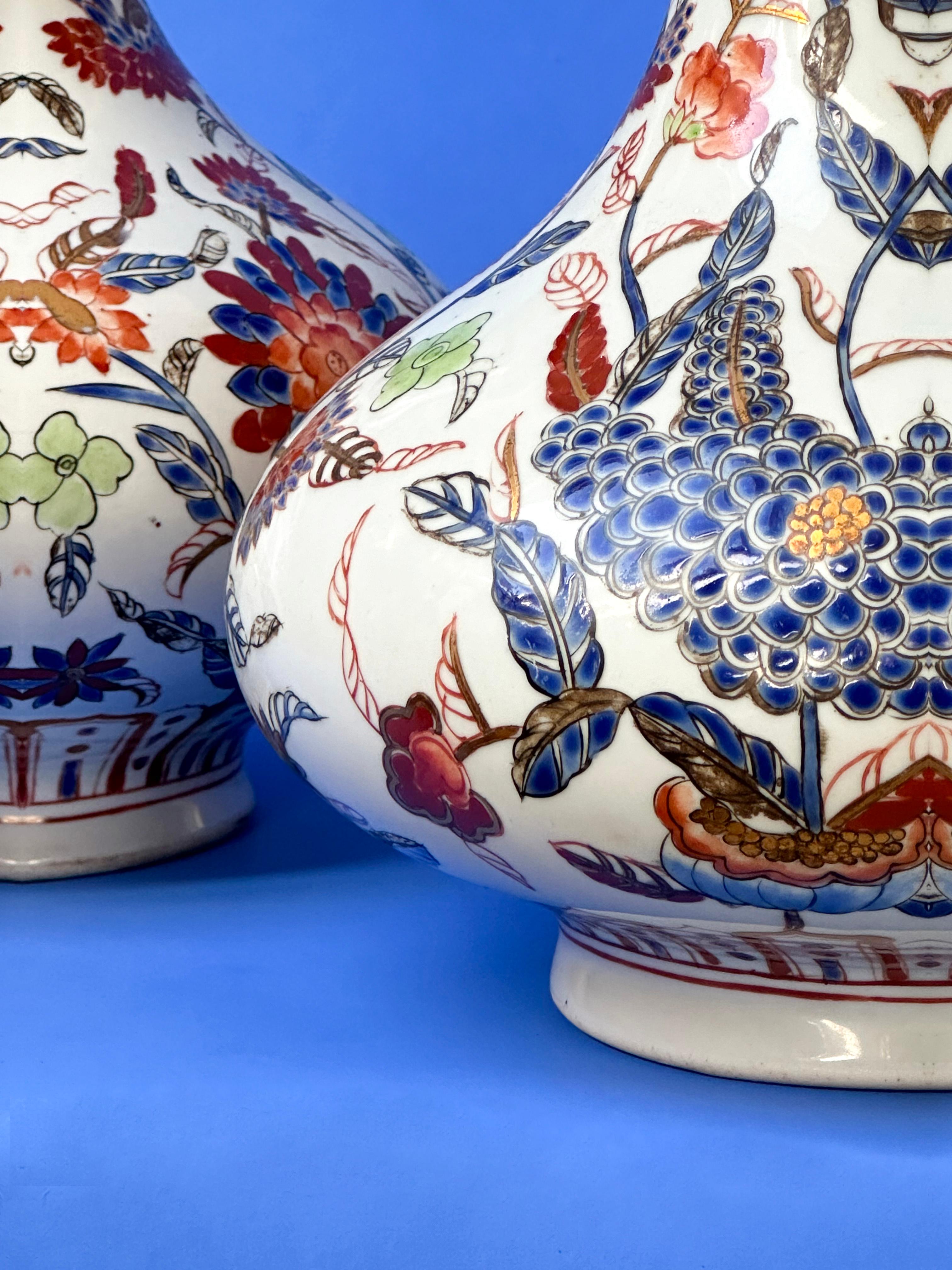 This matching pair of Chinese porcelain vases, features a classic pear shape, which is known as known as 'yuhuchunping'

Each vase is meticulously adorned with an elaborate array of hand-painted, stylised floral motifs in deep red and vibrant blue.