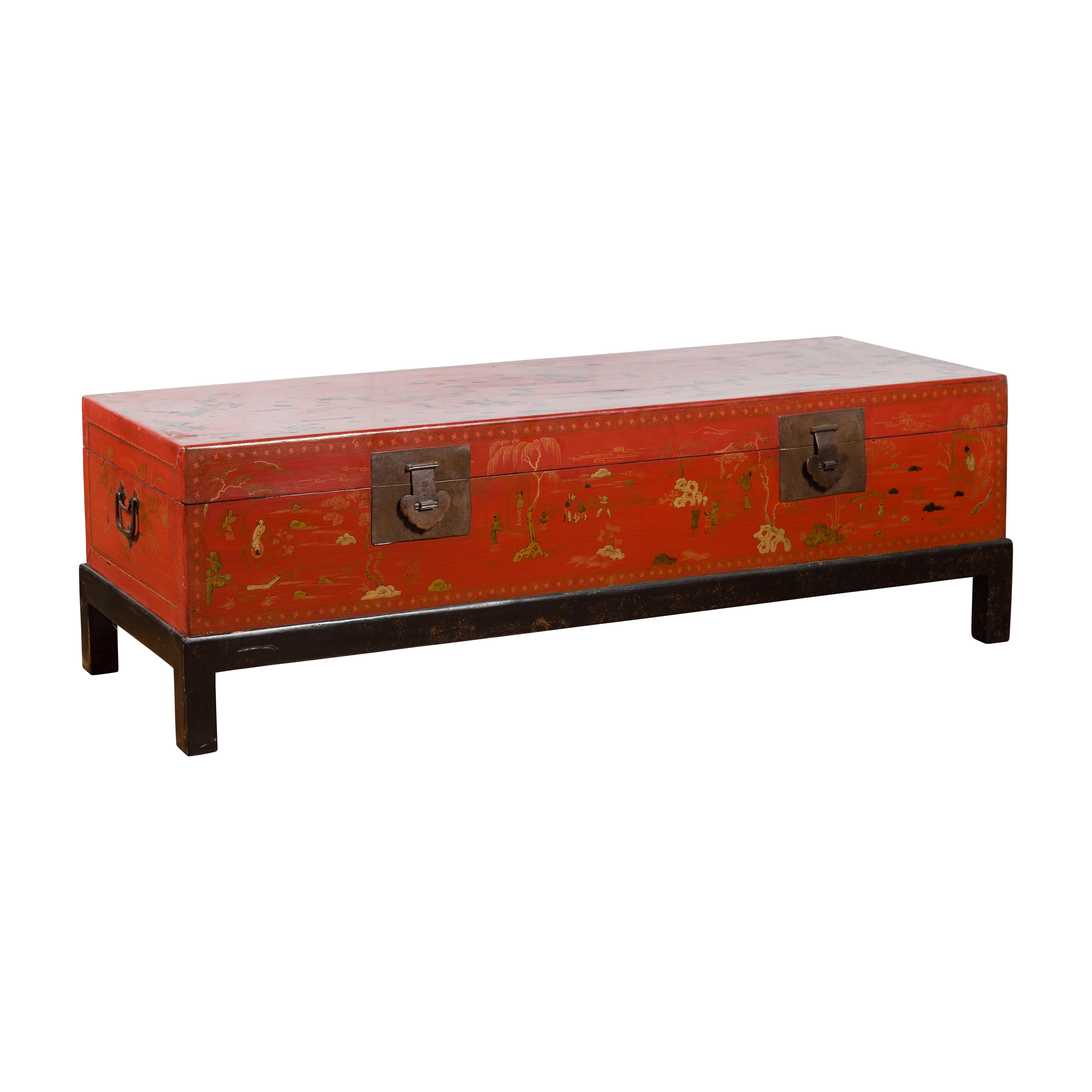 A vintage Chinese red lacquered trunk from the mid-20th century, with gilt Chinoiserie décor and black base. Created in China during the midcentury period, this red lacquered trunk features a rectangular lid adorned with elegant characters in