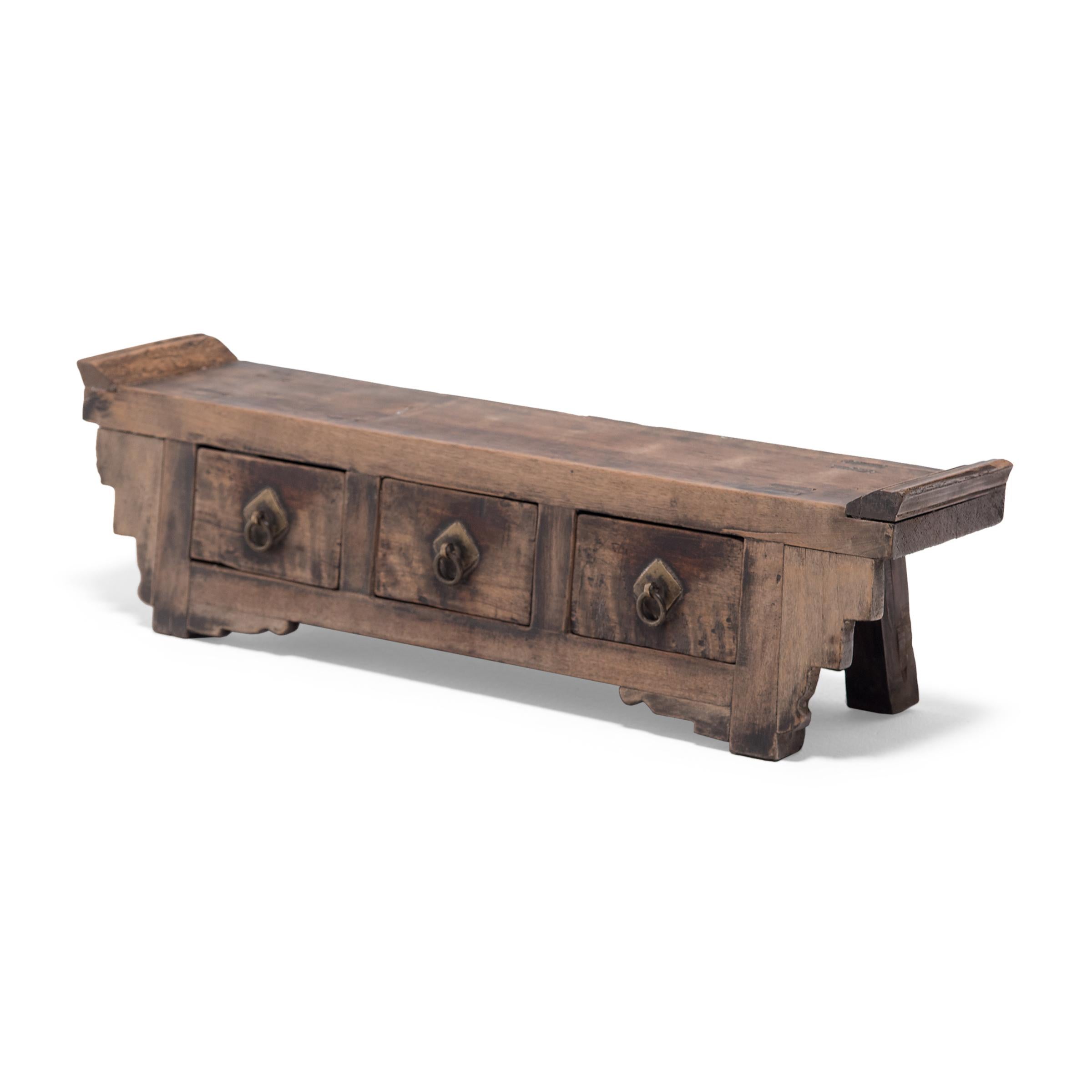 Crafted in Shanxi province in the early 20th century, this wide, three-drawer chest was once used as a home altar for ancestor worship. The plank top surface is framed by everted ends and linked to the sides with decorative stepped spandrels.
