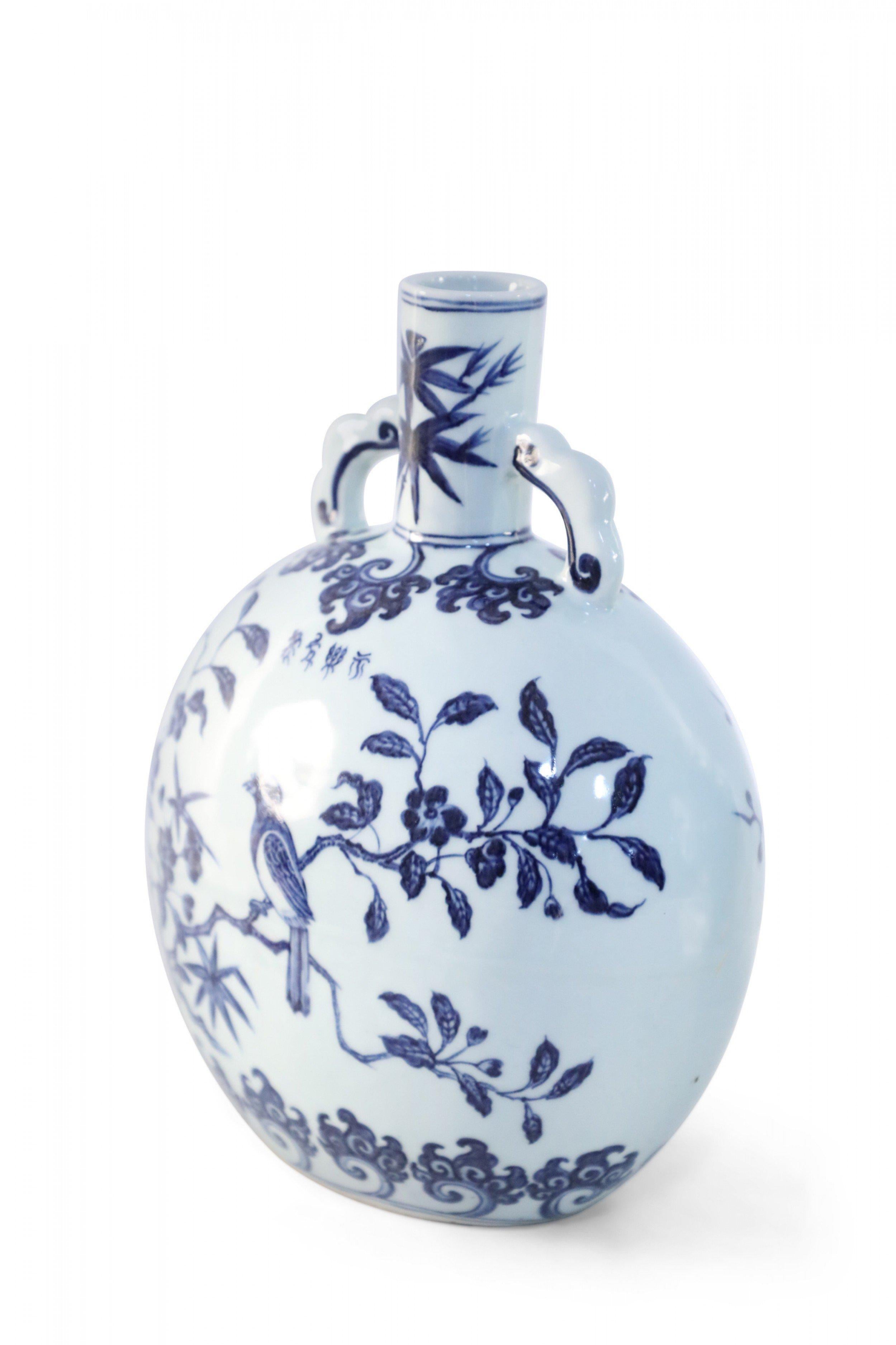 Antico vaso cinese (inizio XX secolo) in porcellana bianca a forma di fiasco di luna, decorato con un uccello appollaiato su fiori di ciliegio e due manici.

Condit: Buono; Usura coerente con l'età e l'utilizzo