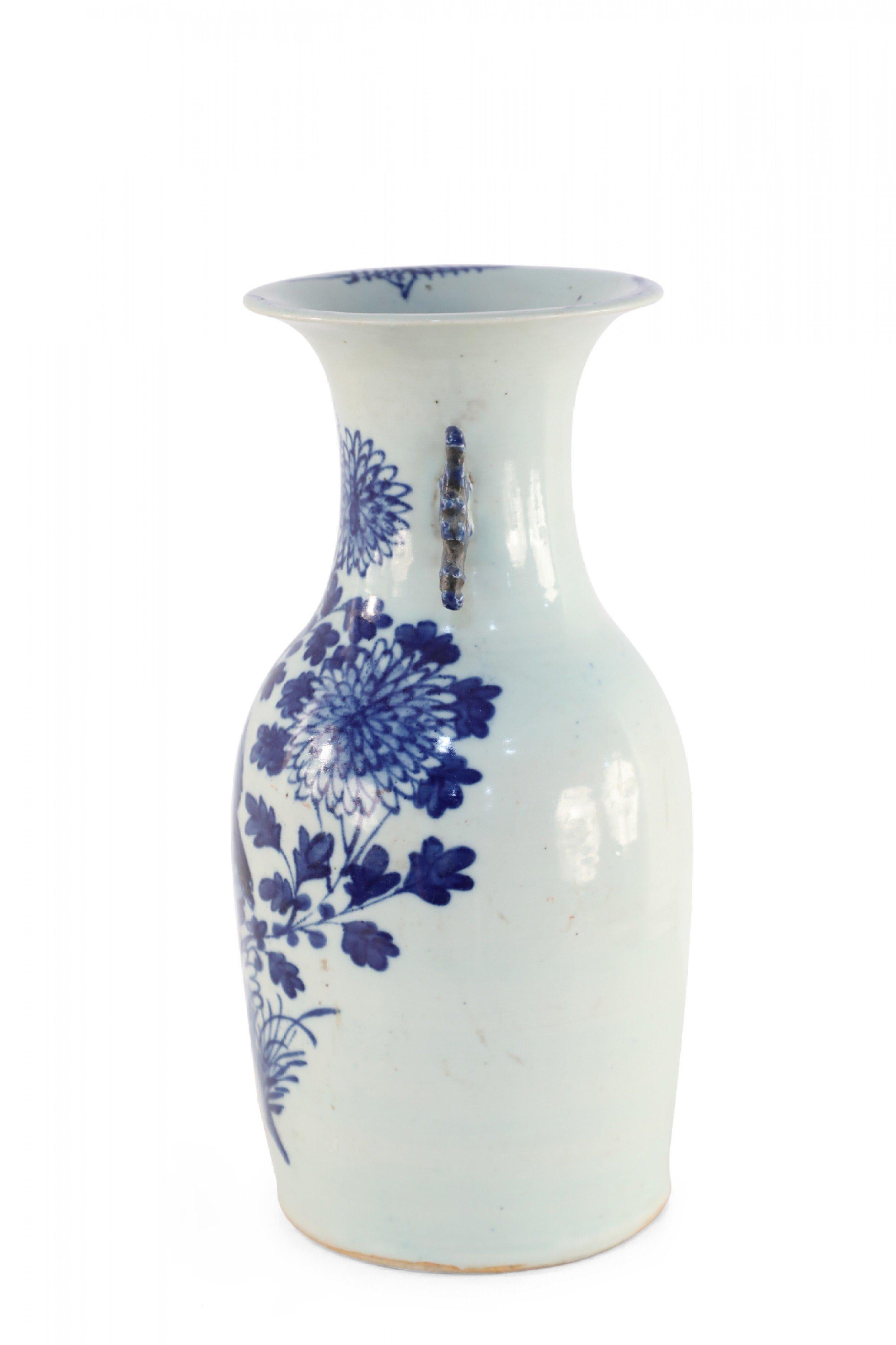 Antique Chinese (Late 19th Century) white and blue porcelain urn decorated with a bird amid flowering chrysanthemums, and accented with two navy scrolled handles along the neck.
 
