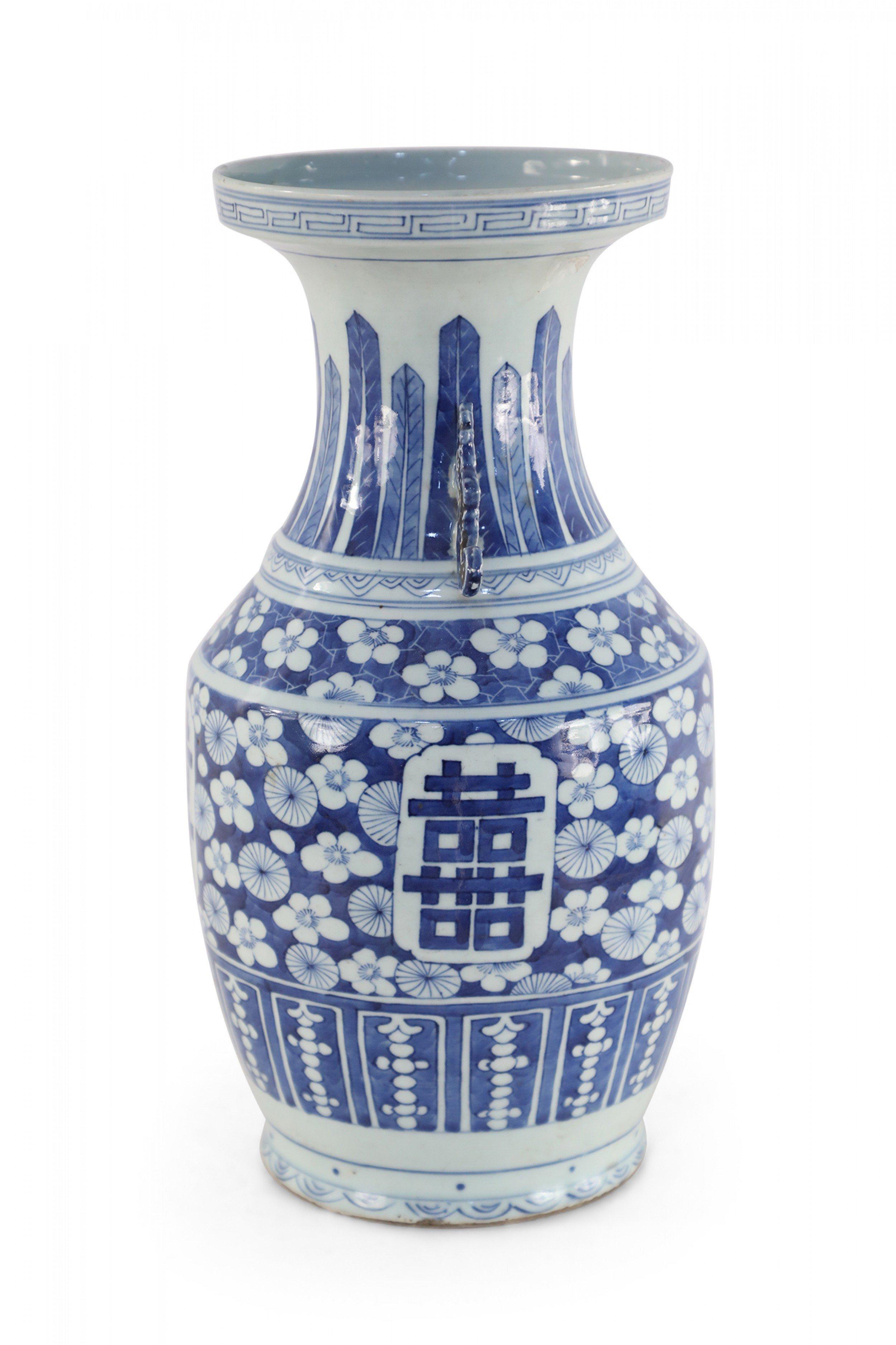 Antique Chinese (Early 20th Century) porcelain urn decorated with a blue geometric floral pattern surrounding a centered emblem with dark blue characters, a Greek key band around the lip, and two navy scrolled handles along the neck.
  