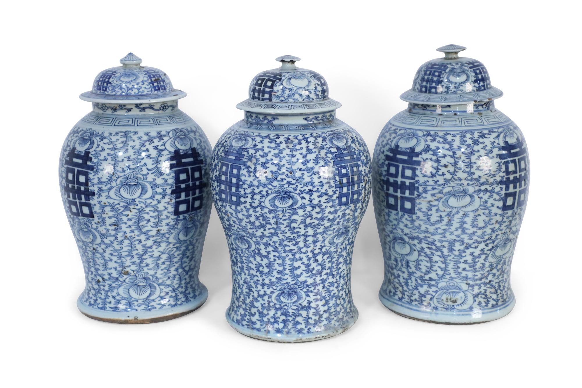 3 antique Chinese (late 19th century) similar lidded ceramic urns with blue floral designs surrounding bold, centered characters on 4 sides (jars vary slightly in size, pattern, and color) (priced each).
     