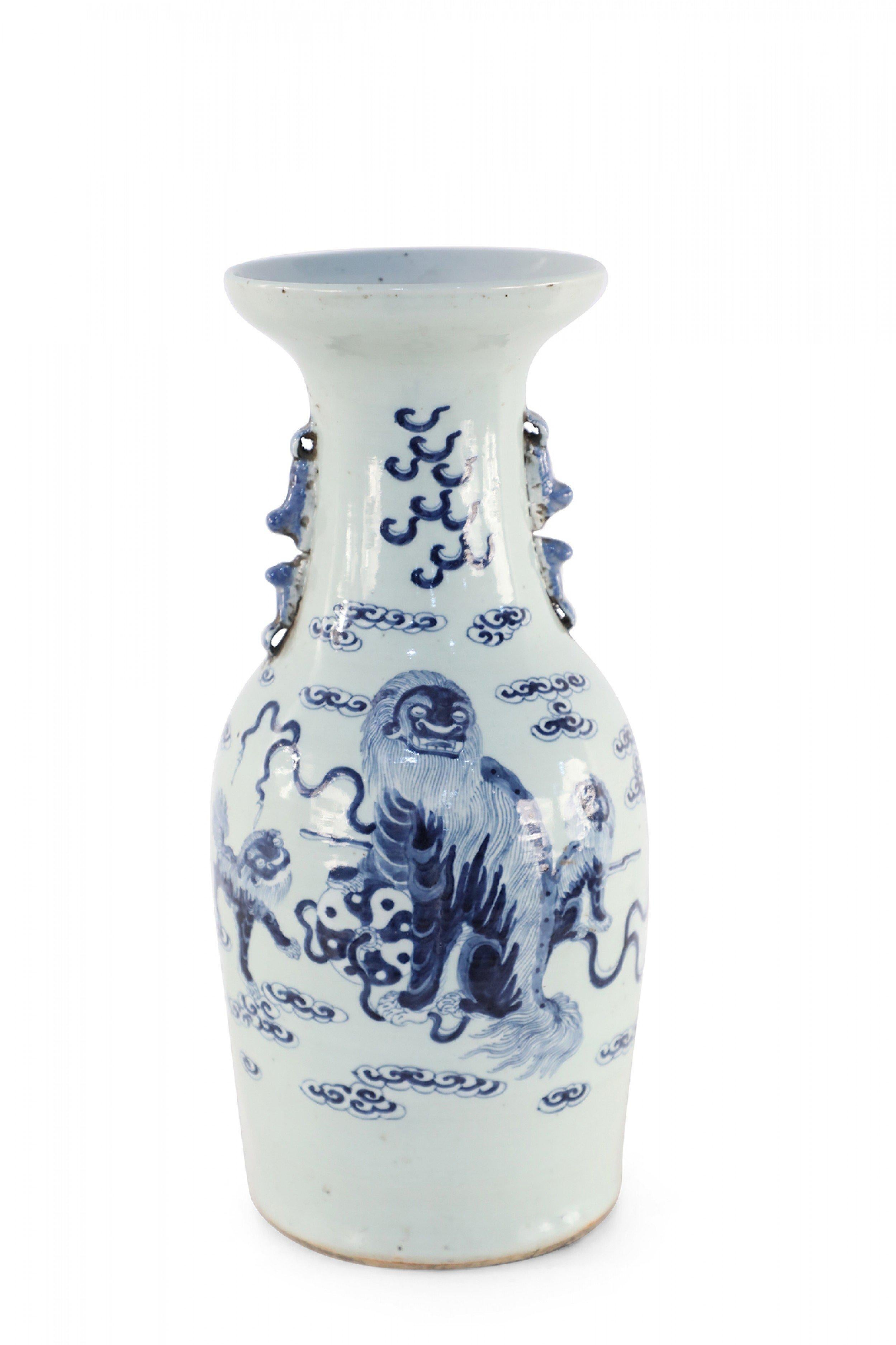 Antique Chinese (Late 19th century) white porcelain urn decorated with blue foo dogs, clouds, and serpents, and accented in two pale blue scrolled handles along the neck.
   