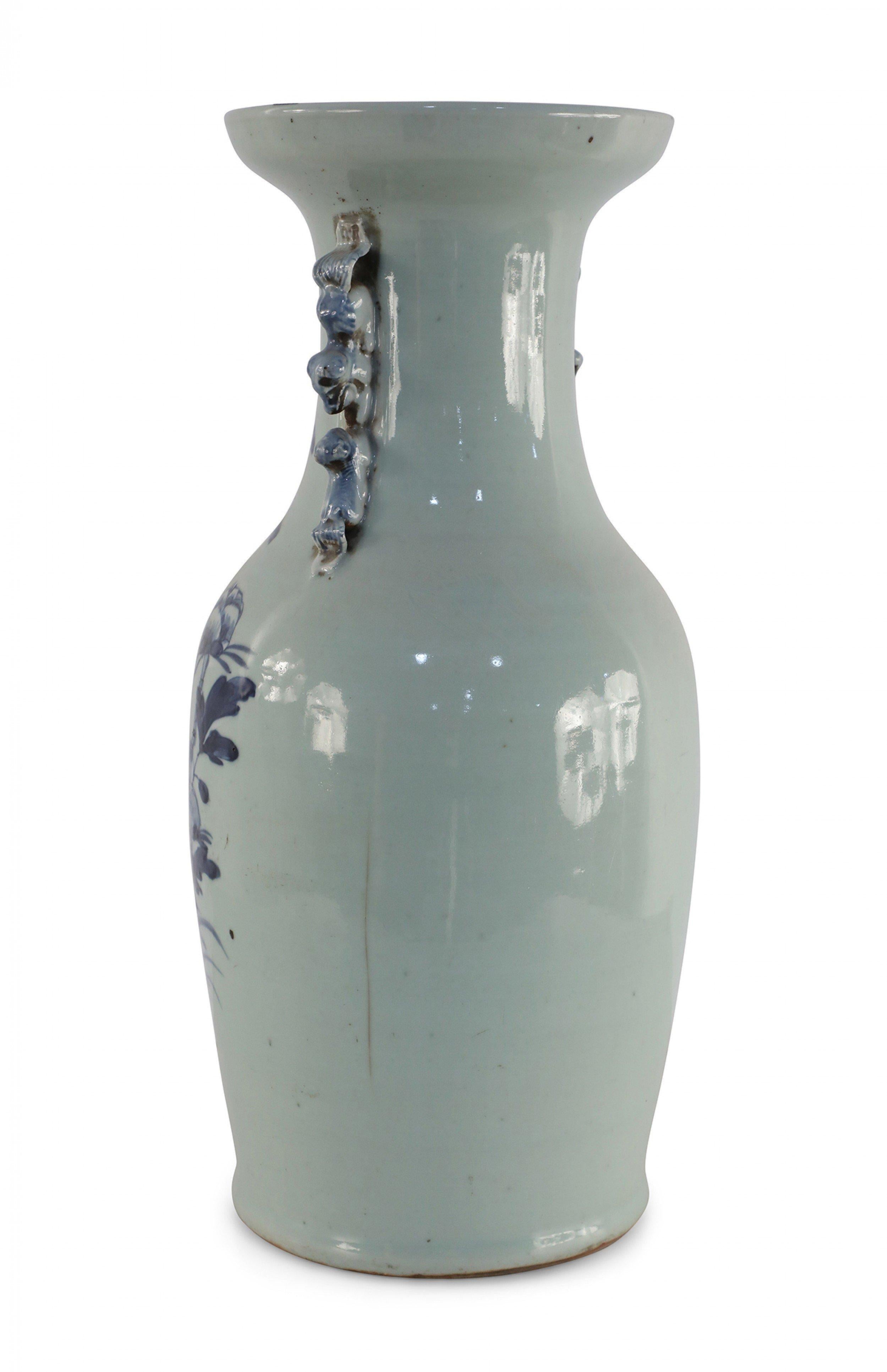 Antique Chinese (Late 19th Century) white, porcelain urn decorated in a blue scene of a bird perched on a flowering branch above water, and accented with two light blue scrolled handles along the neck.
  