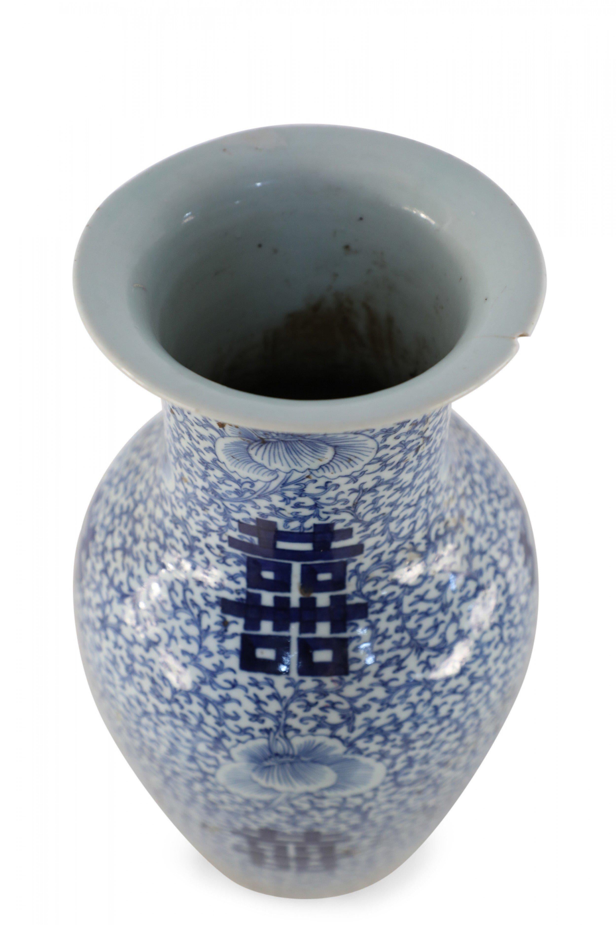 Antique Chinese (Early 20th Century) white porcelain urn decorated with an all-over blue vine and flower patterned ground, surrounding spaced bold, blue characters. 
 
