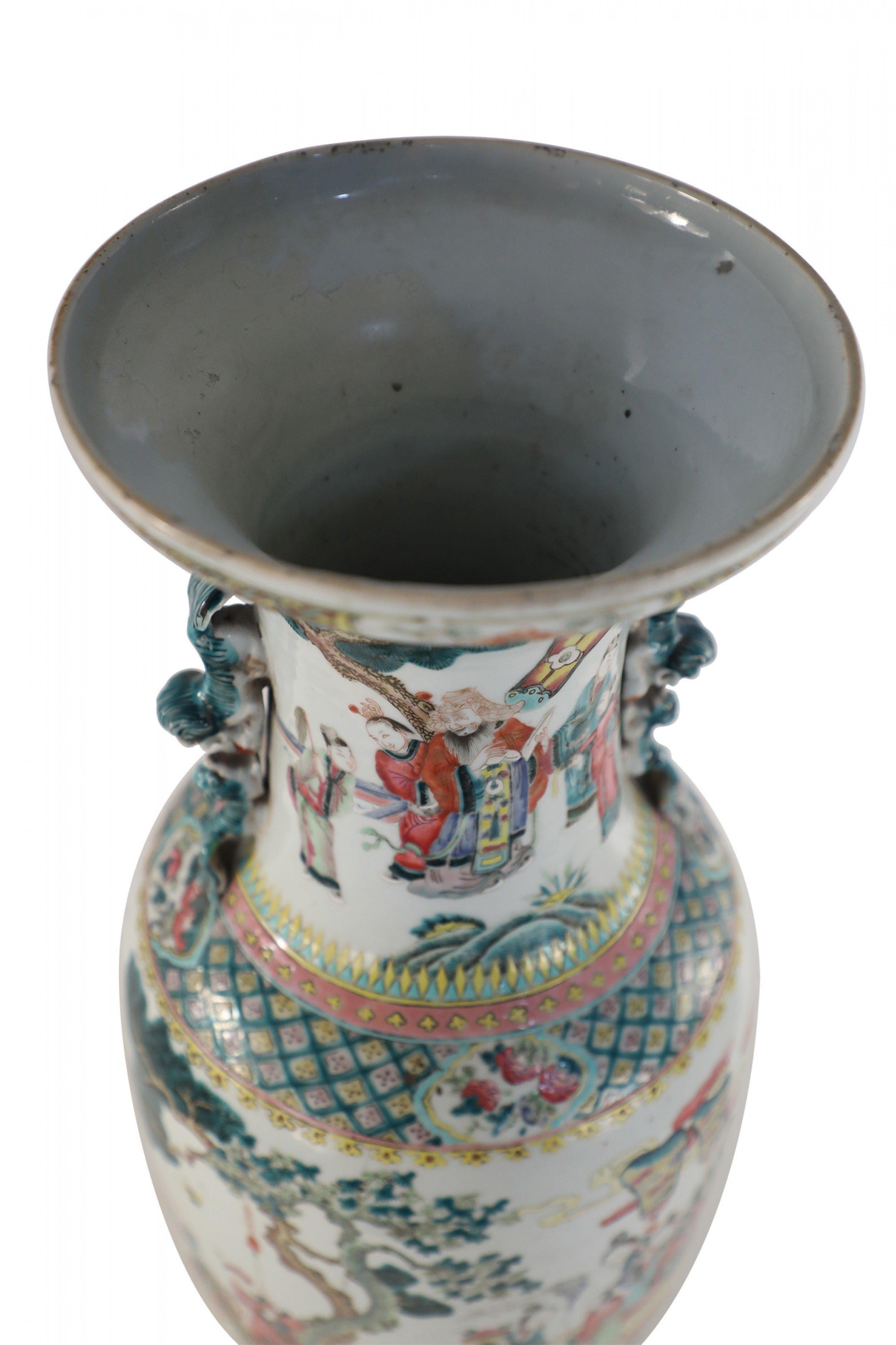 Antique Chinese (Late 19th Century) white porcelain urn decorated with a detailed and lively scene of people gathering in a pastoral setting and blue foo dog handles along the neck.
 