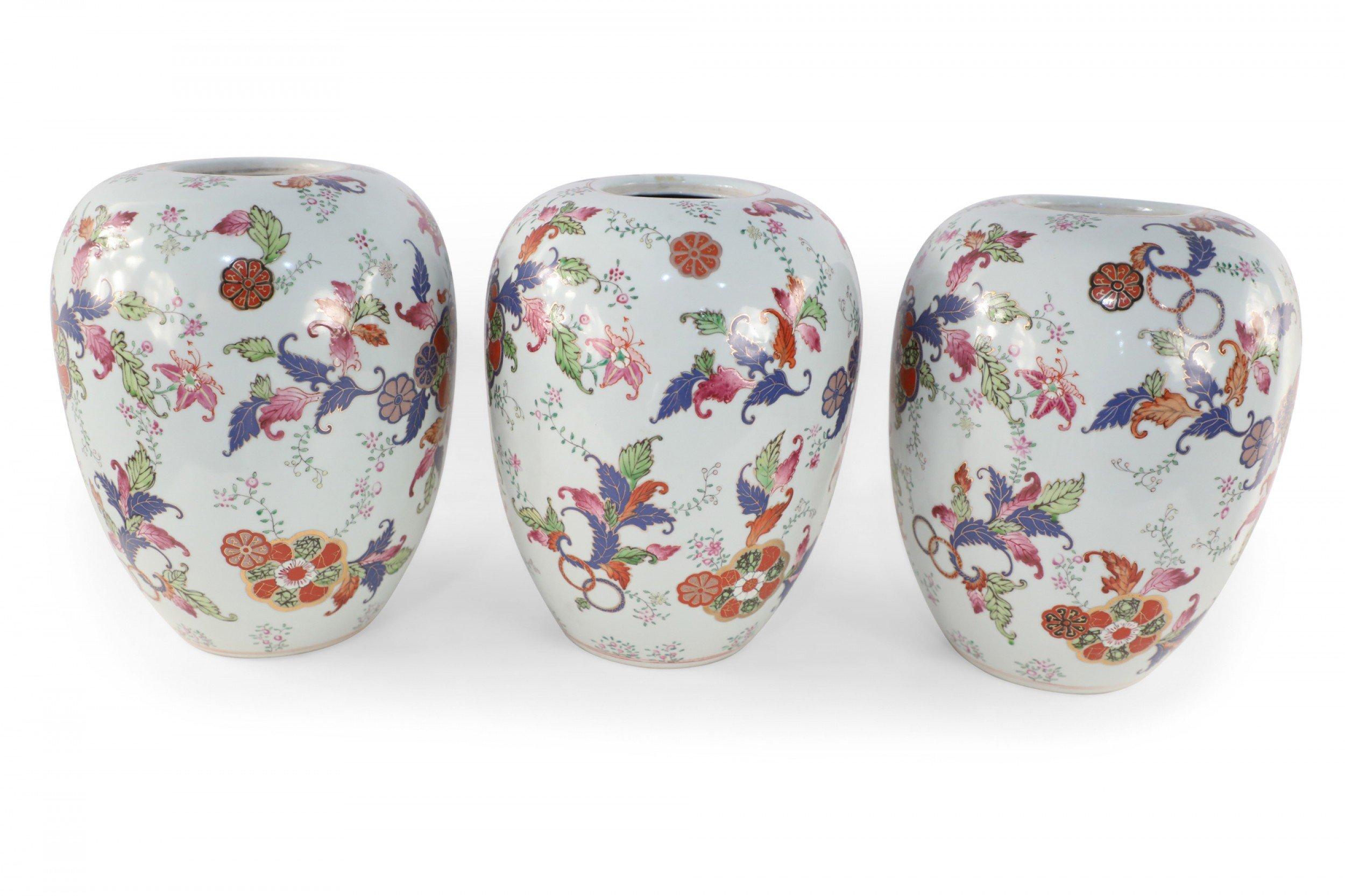 5 Chinese white porcelain, open-mouthed jars decorated in an all-over pattern of florals and foliage in purple, orange and green, accented with gold lotus flowers (Priced each).
 
