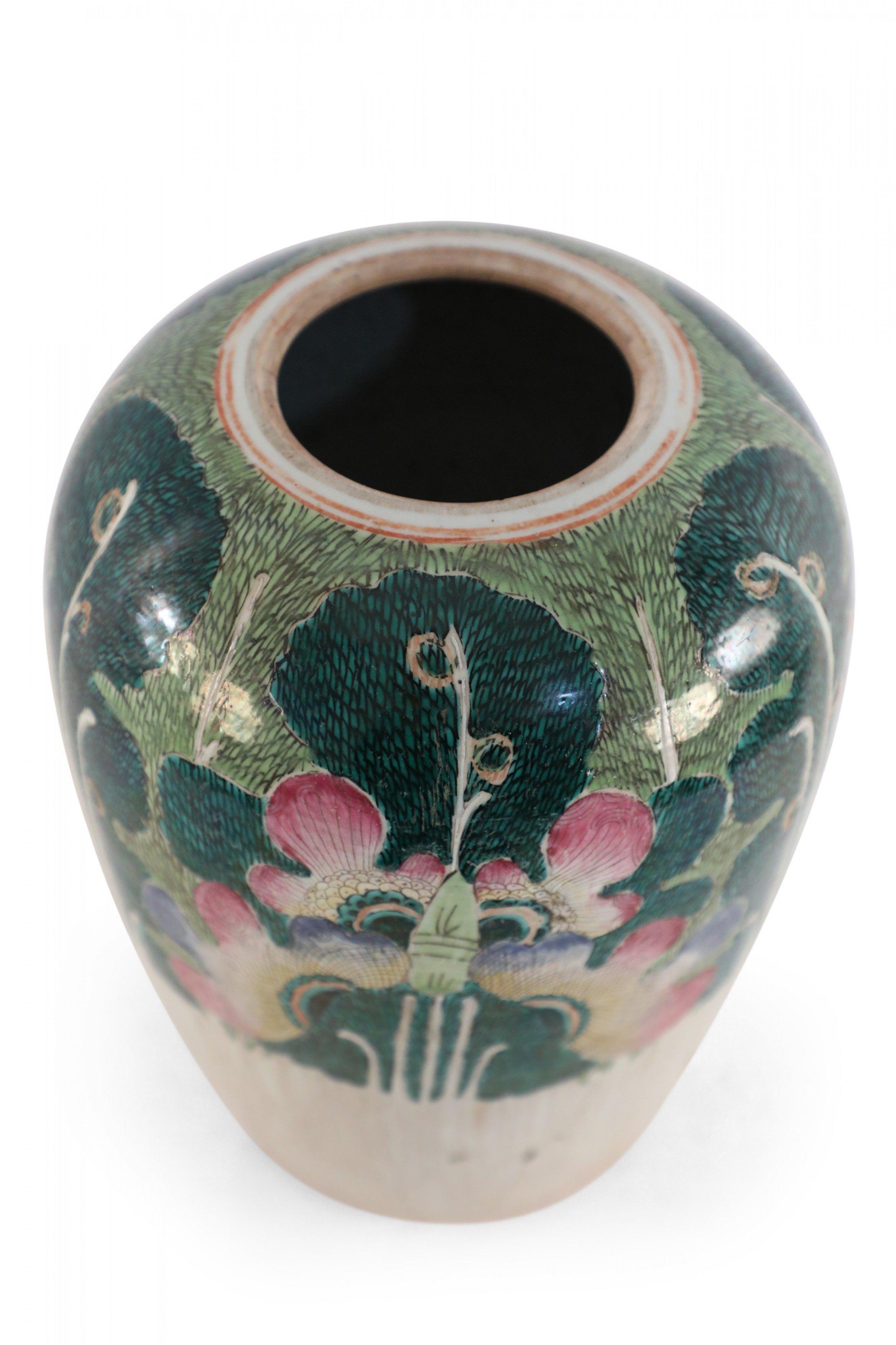Antique Chinese (Early 20th Century) winter melon-form porcelain vase decorated with an incised, white bottom half that grows into verdant abstracted vegetal and peacock shapes on the top half in hues of green, pink and purple. The base includes a