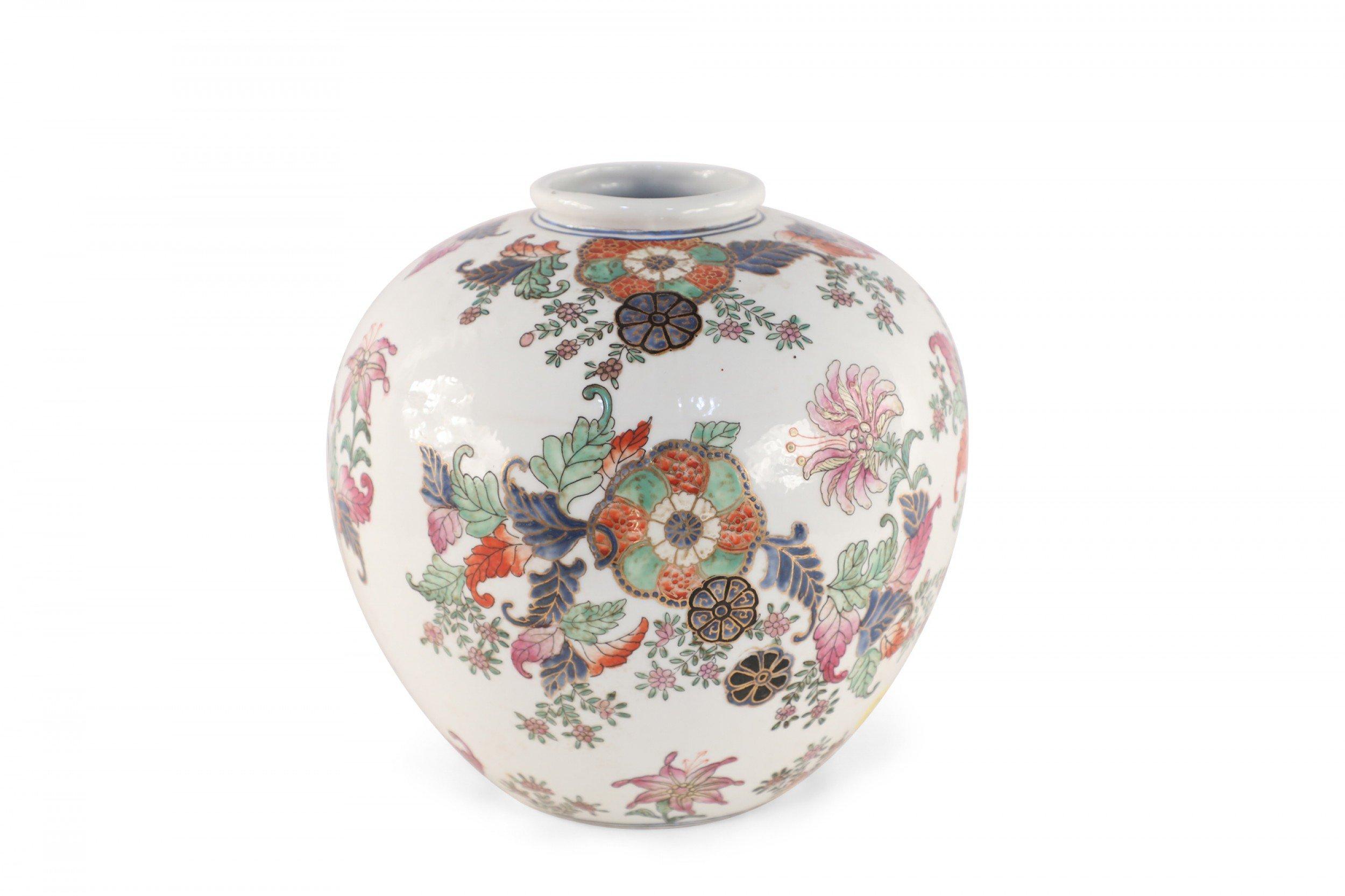 Chinese white, round porcelain vase decorated in a pink, green, orange and blue floral designs, accented in gold detailing.
     