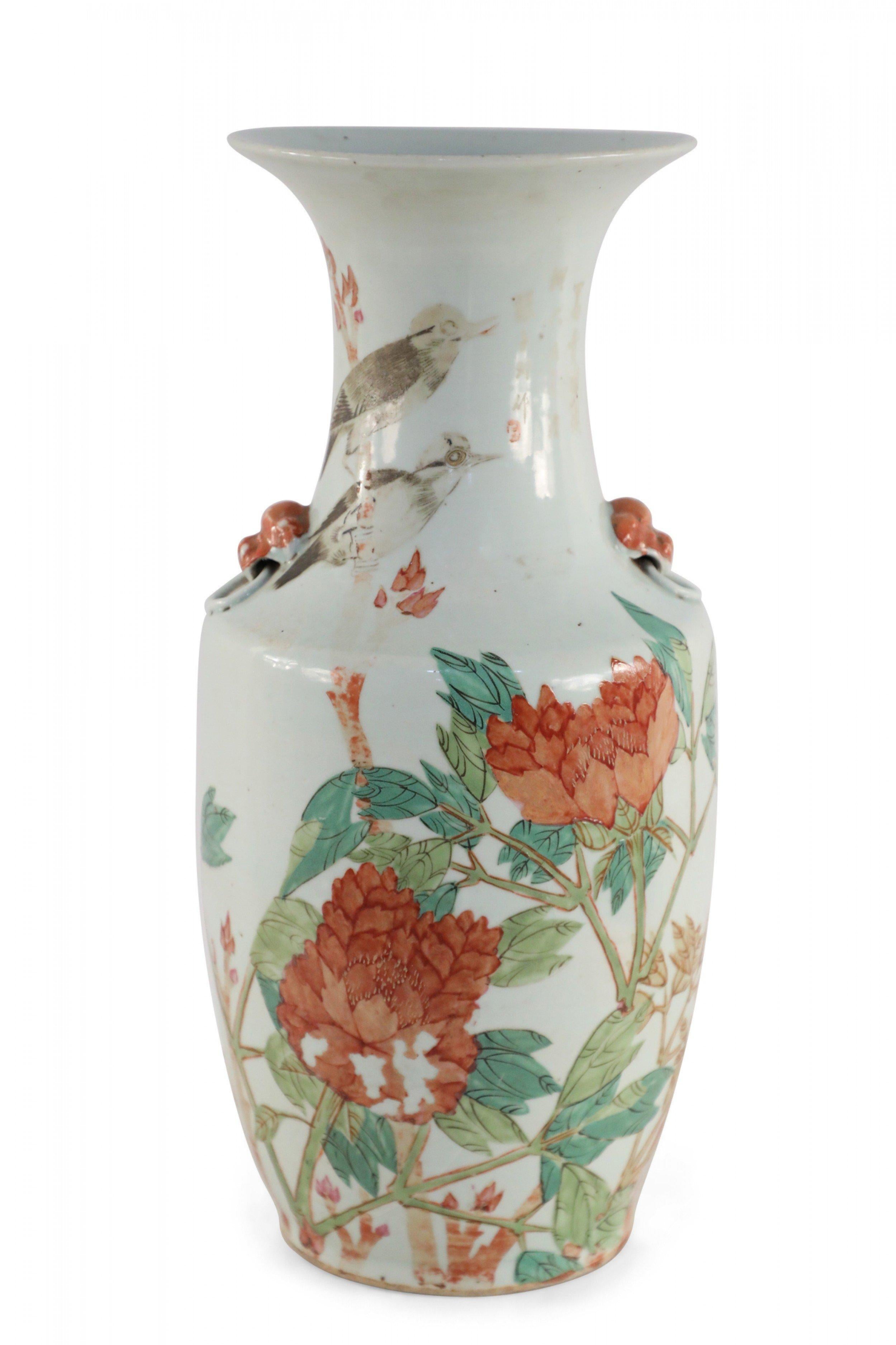 Antique Chinese (Early 20th Century) white porcelain urn decorated with green and blooming orange florals with two birds perched on a nearby branch, and accented with orange dog doorknocker ornamentations on the neck.
 