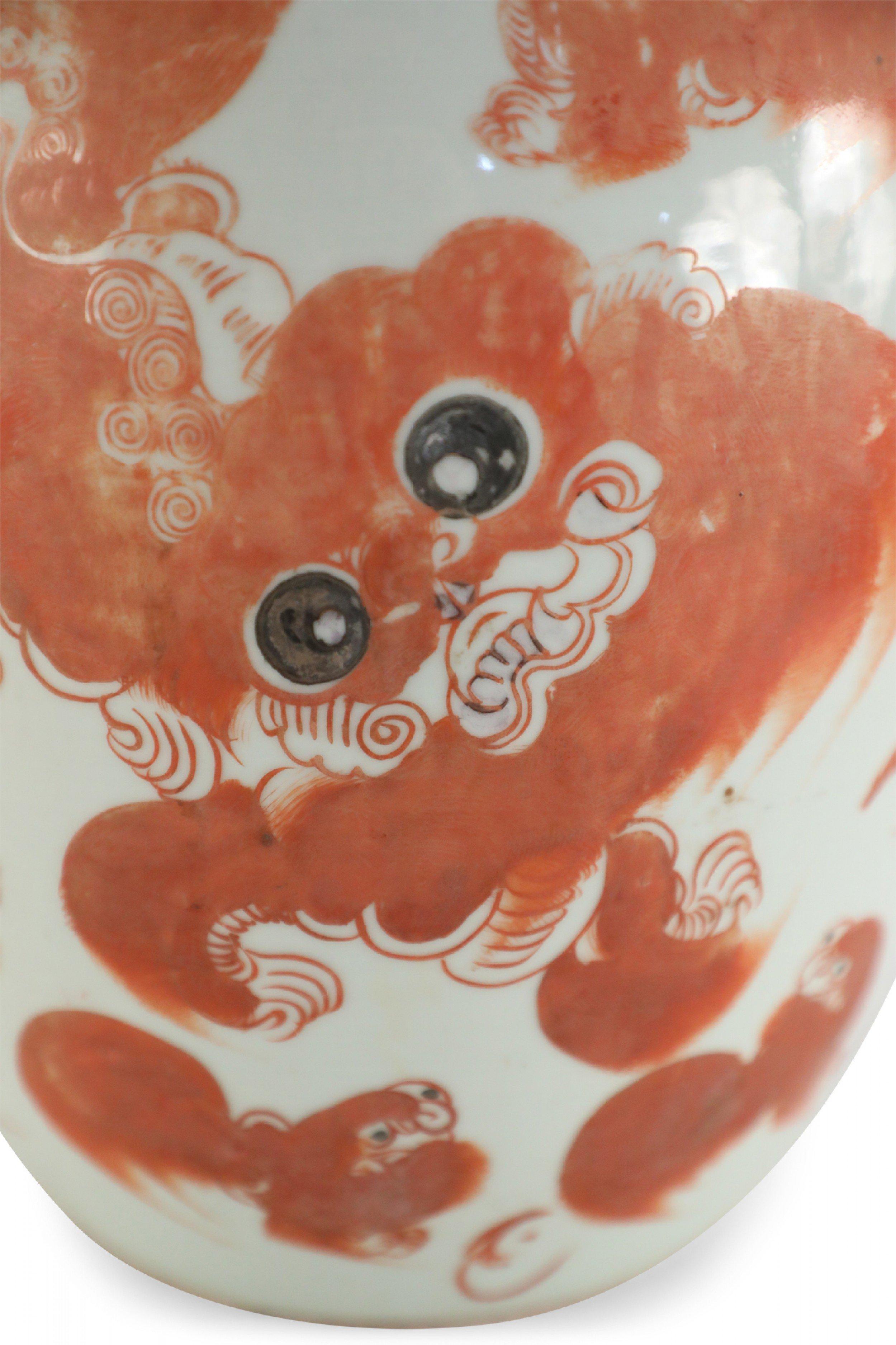 Antique Chinese (Early 20th Century) white porcelain vase with an elongated, rounded winter melon form decorated in an orange foo dog on one side and characters on the reverse.
  