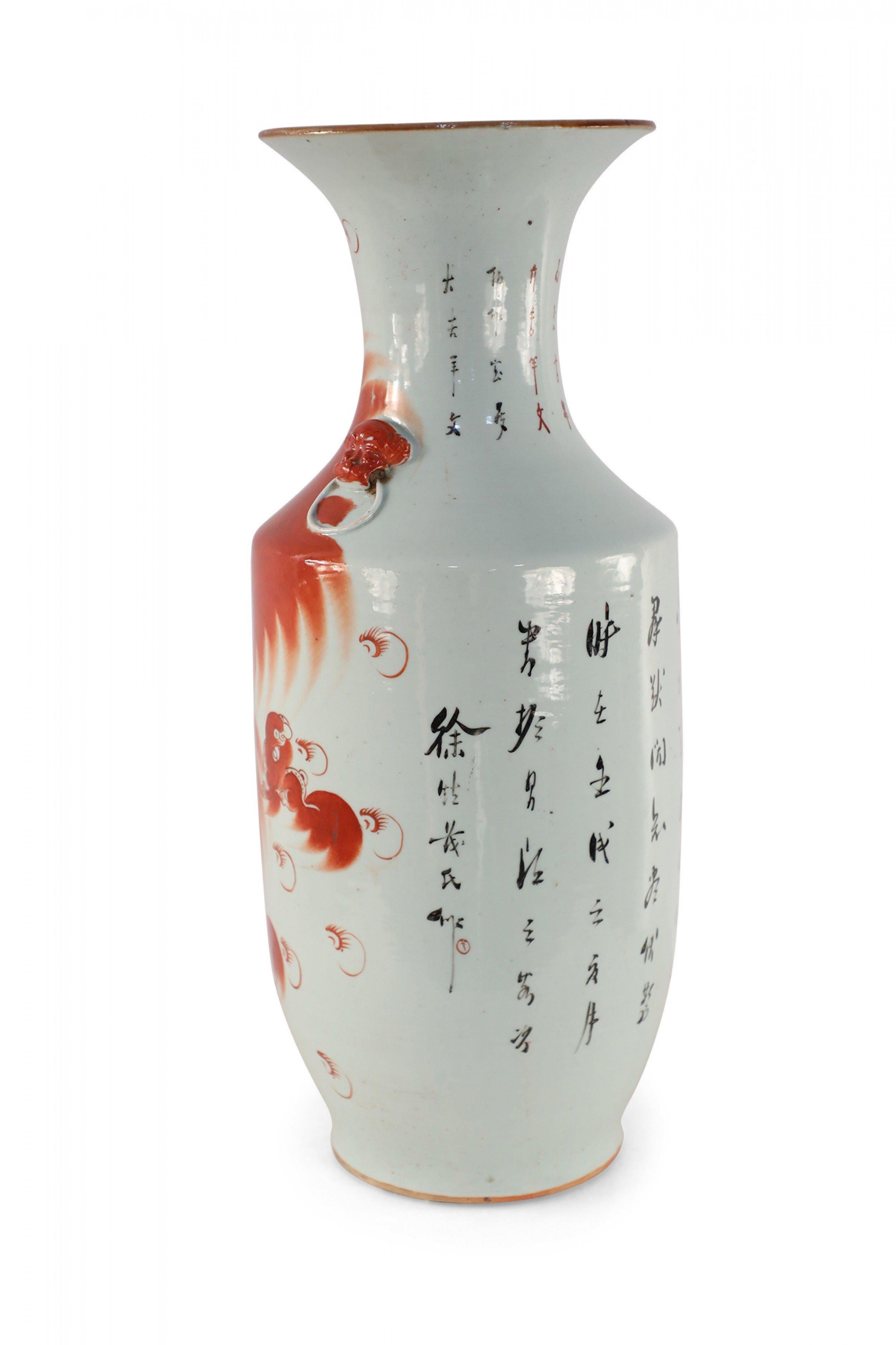 Antique Chinese (Early 20th Century) white porcelain urn with a sprawling and spirited depiction of a foo dog - signifying prosperity and academic achievements - on one side, characters on the reverse, and foo dog doorknocker ornamentation on the