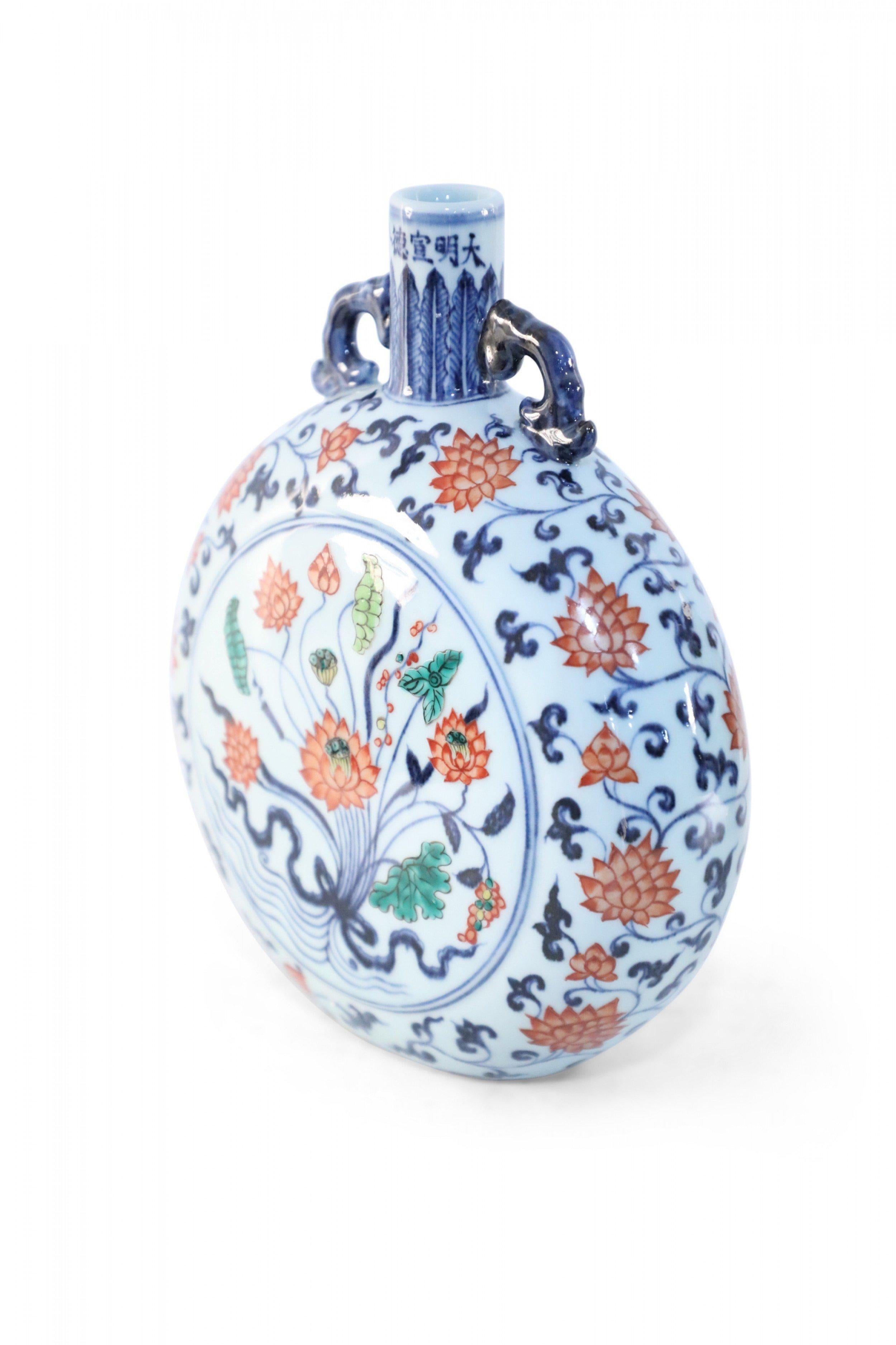 Antico vaso cinese (inizio XX secolo) a forma di fiasco di luna bianco, decorato con un disegno botanico centrale circondato da fiori blu e arancioni e sormontato da due manici blu.

Condit: Buono; Usura coerente con l'età e l'utilizzo