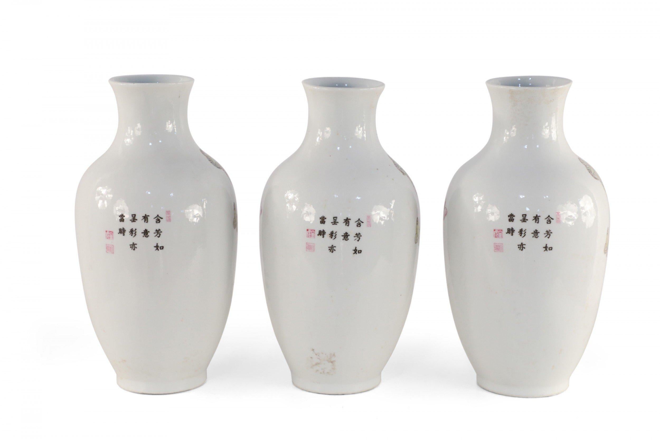 3 Chinese white porcelain vases with pear-shaped forms decorated in butterflies above pink and orange florals growing from green leaves on one side with characters on the reverse. (Priced each).
 