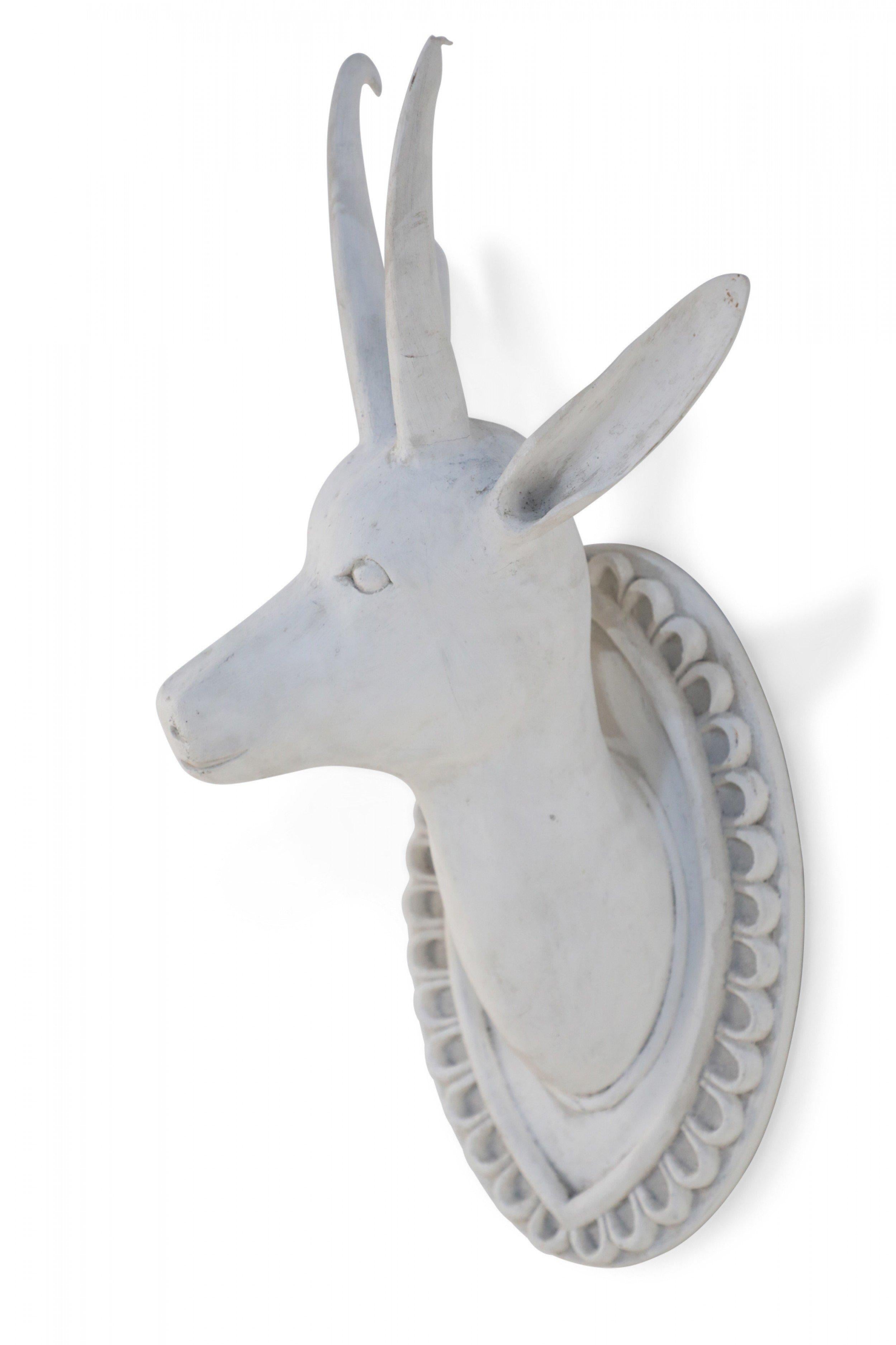 Chinese mid century hand-carved, white gesso wall plaque depicting a horned goat head emerging from an ornamental plaque.