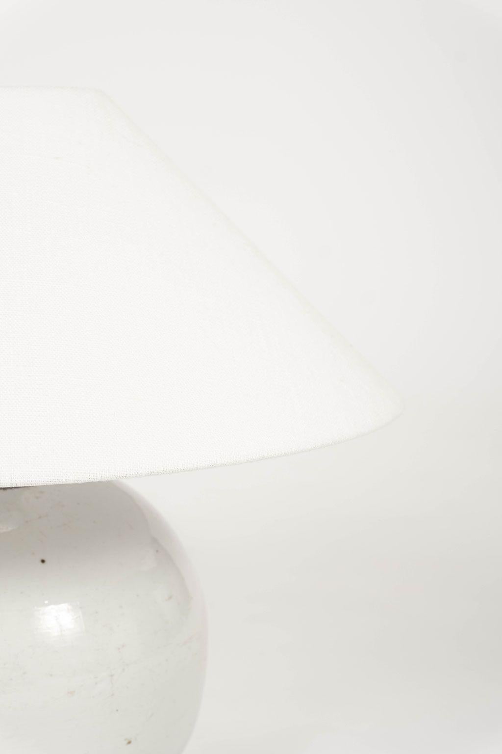 Chinese white ginger jar lamp: white glazed ginger jar, newly wired for use within the USA. Includes linen coolie shade with rolled edges. Two ginger jar lamps are available (see last image) and sold individually priced $2,200 each.