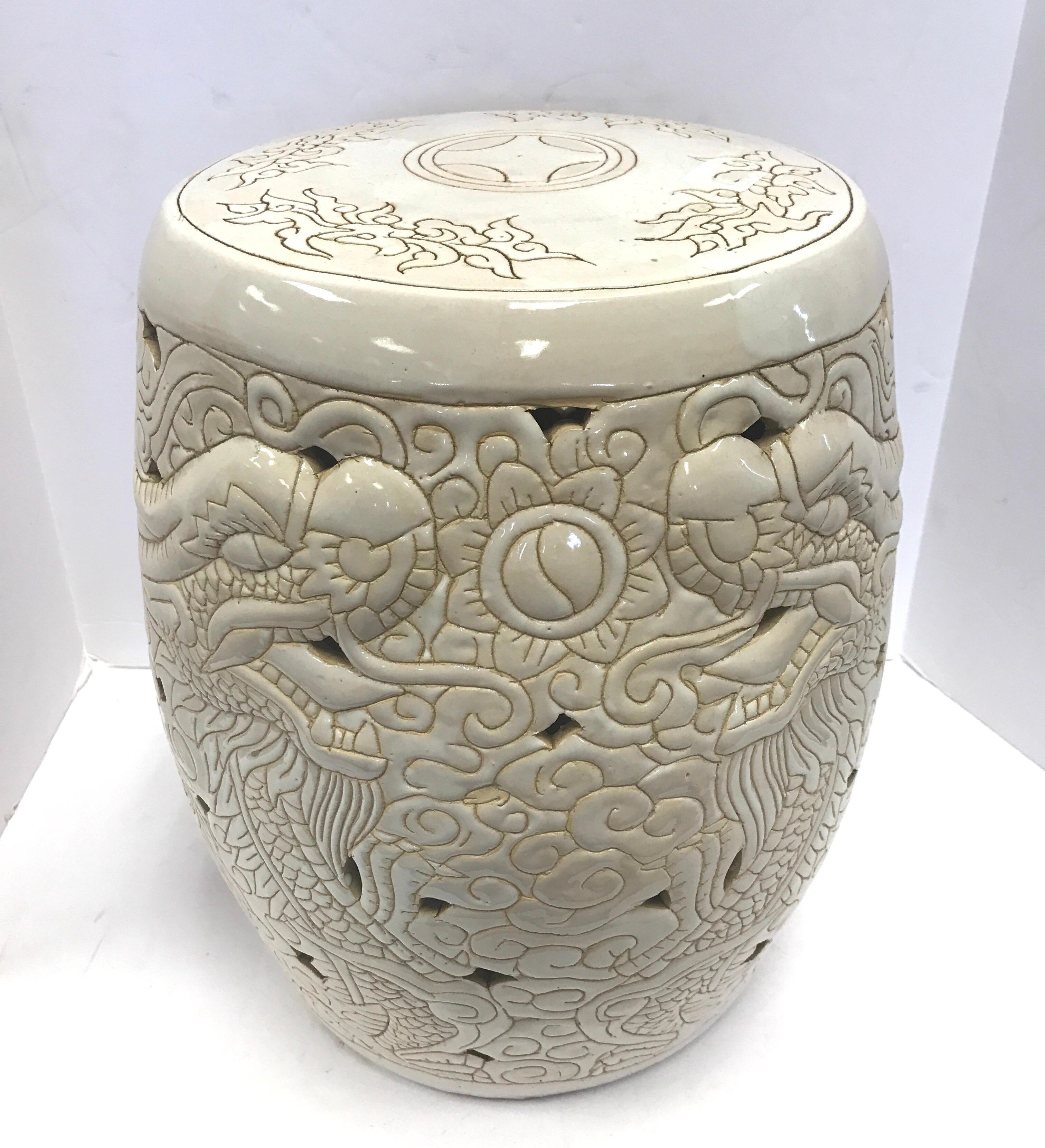Porcelain drum form finished in warm white glaze with hand-incised tan line work artfully depicting fierce dragons, swirling smoke, flowers and foliage. Design is pierced throughout.