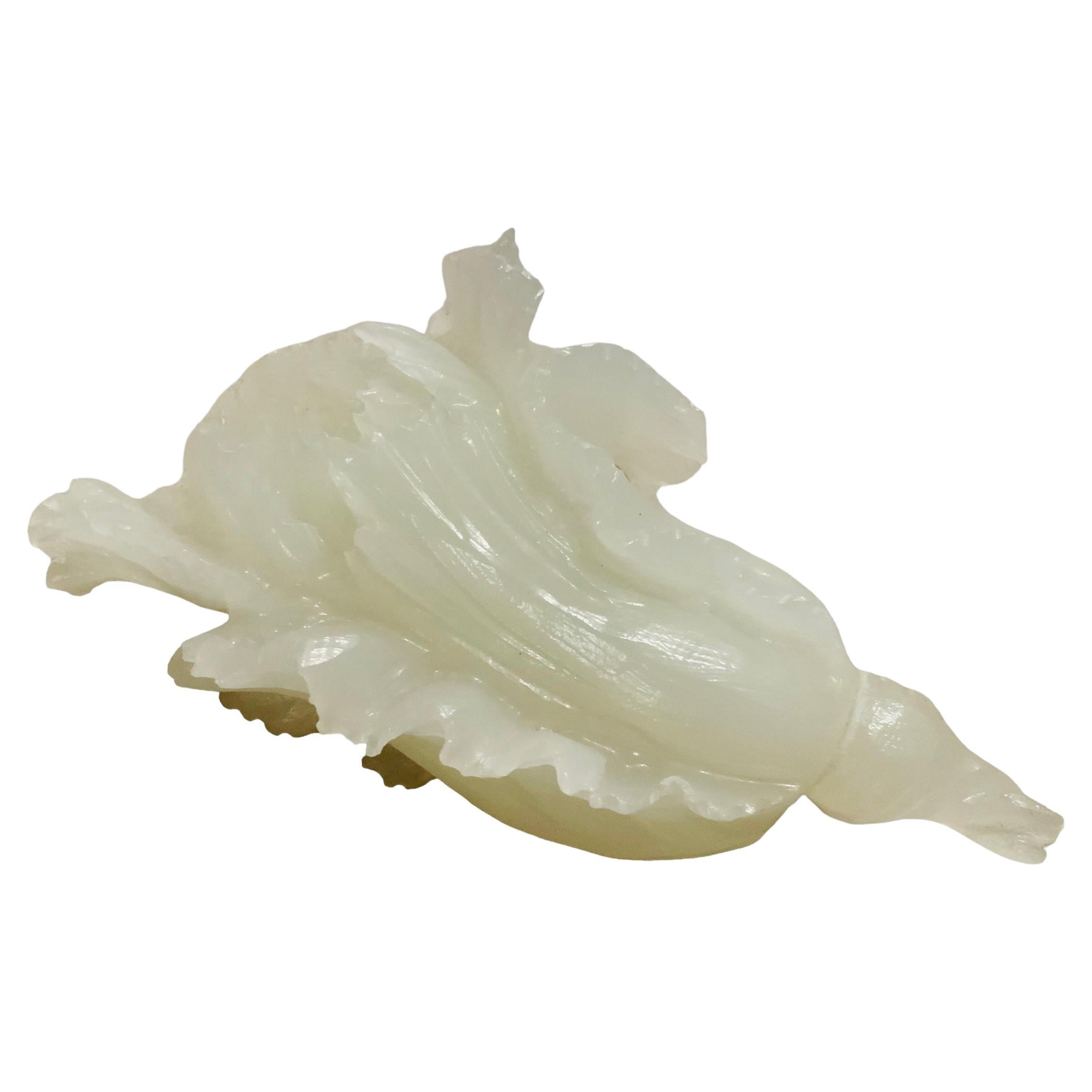 Si tratta di una piccola scultura di cavolo in giada bianca cinese. Raffigura una delicata scultura di cavolo bianco molto ben scolpita a mano. Si trova su una base di legno allungata. Nella cultura cinese, il cavolo simboleggia la buona fortuna, la