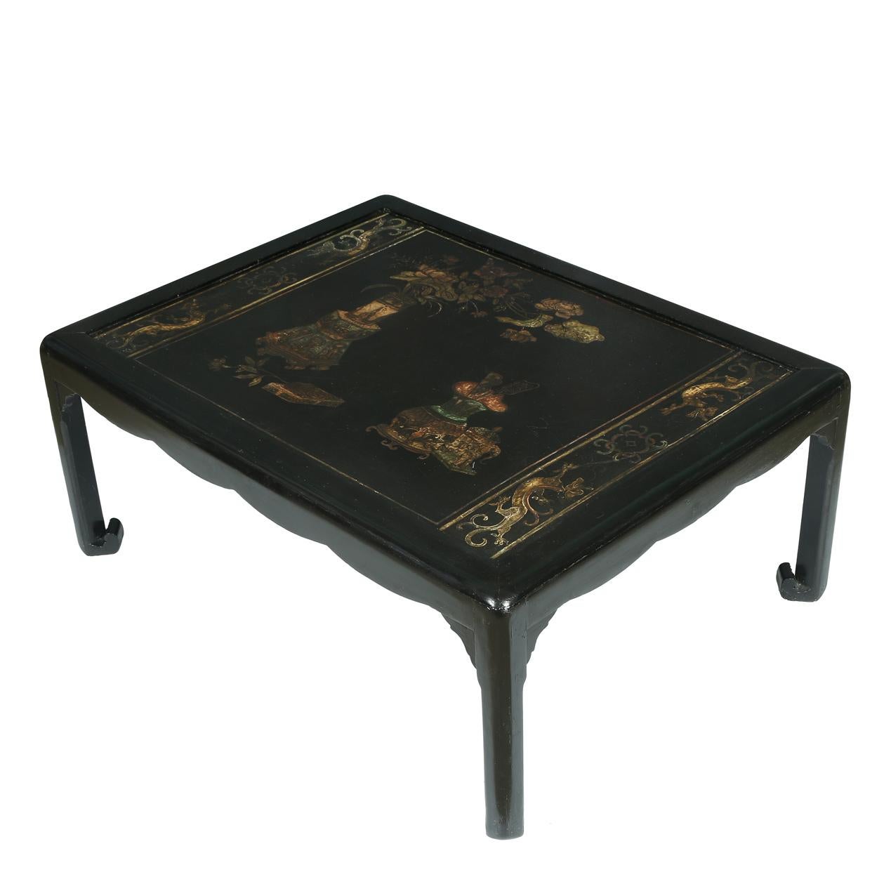 Black Chinese wood coffee table with chinoiserie painted decoration.  A glass top sits on top to protect the table and provides a flat surface.