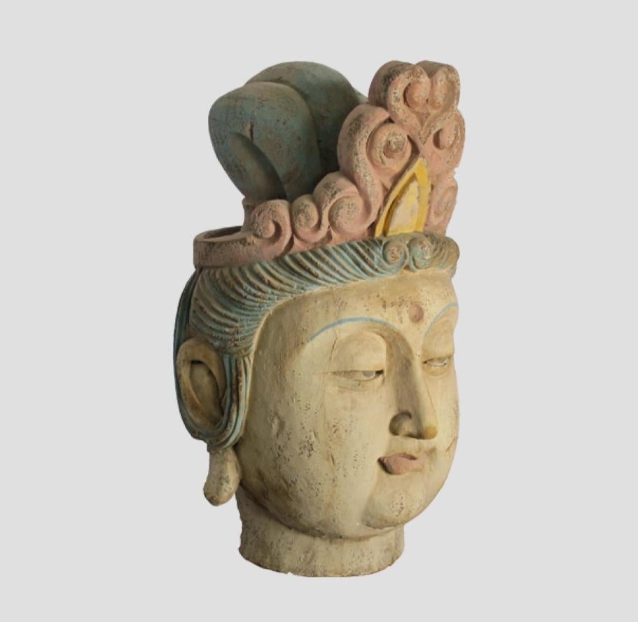 This sculpture of Guan Yin head was rescued from a collapsing temple. It was beautifully carved with the faded polychrome headdress and rich patina. It is in great condition.