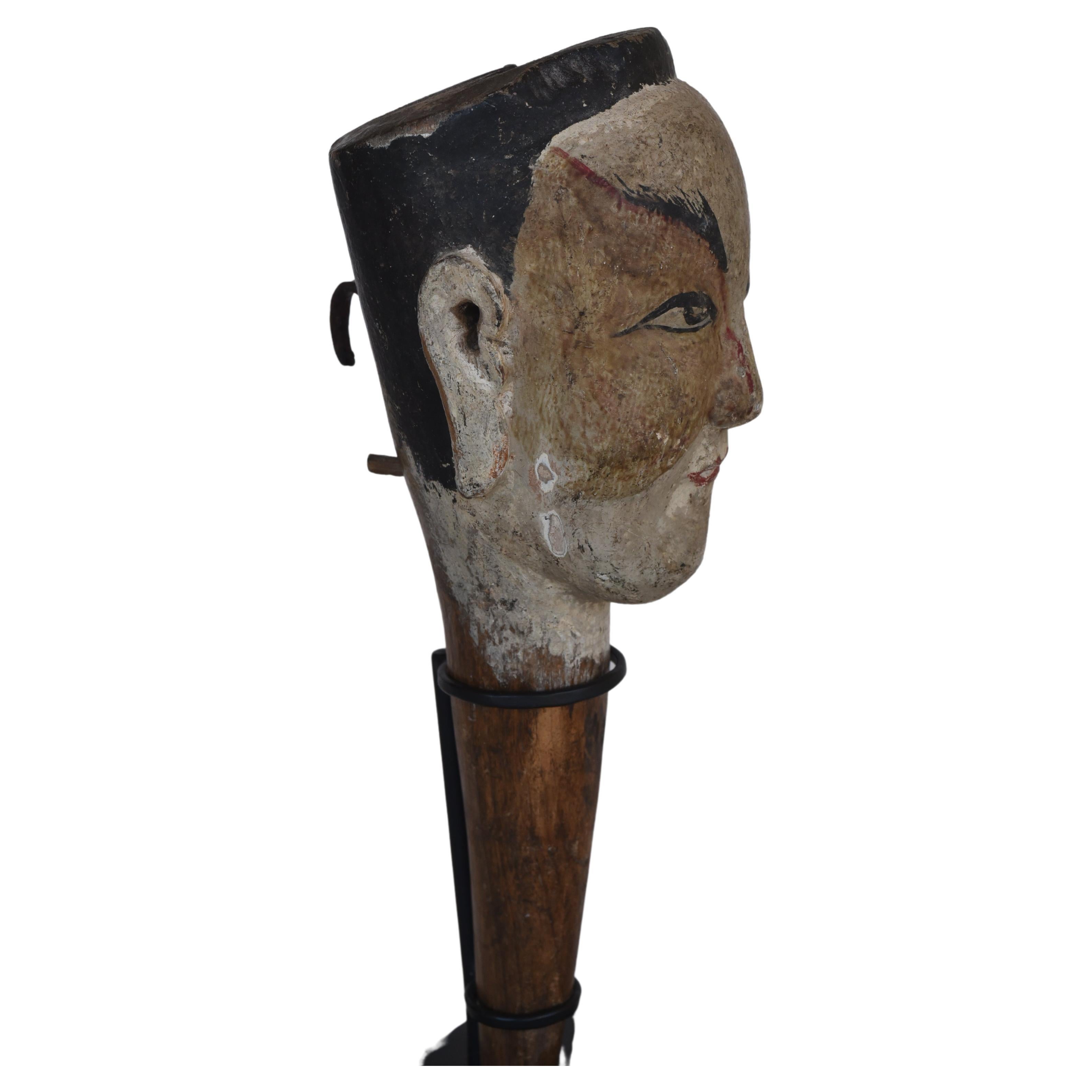 Chinese wood puppet head, 19th century, mounted on contemporary stand. 

Simple puppet head of a male figure, carved out of a single piece of wood, with tapering neck, lightly carved features, painted face, minor signs of wear, overall fine