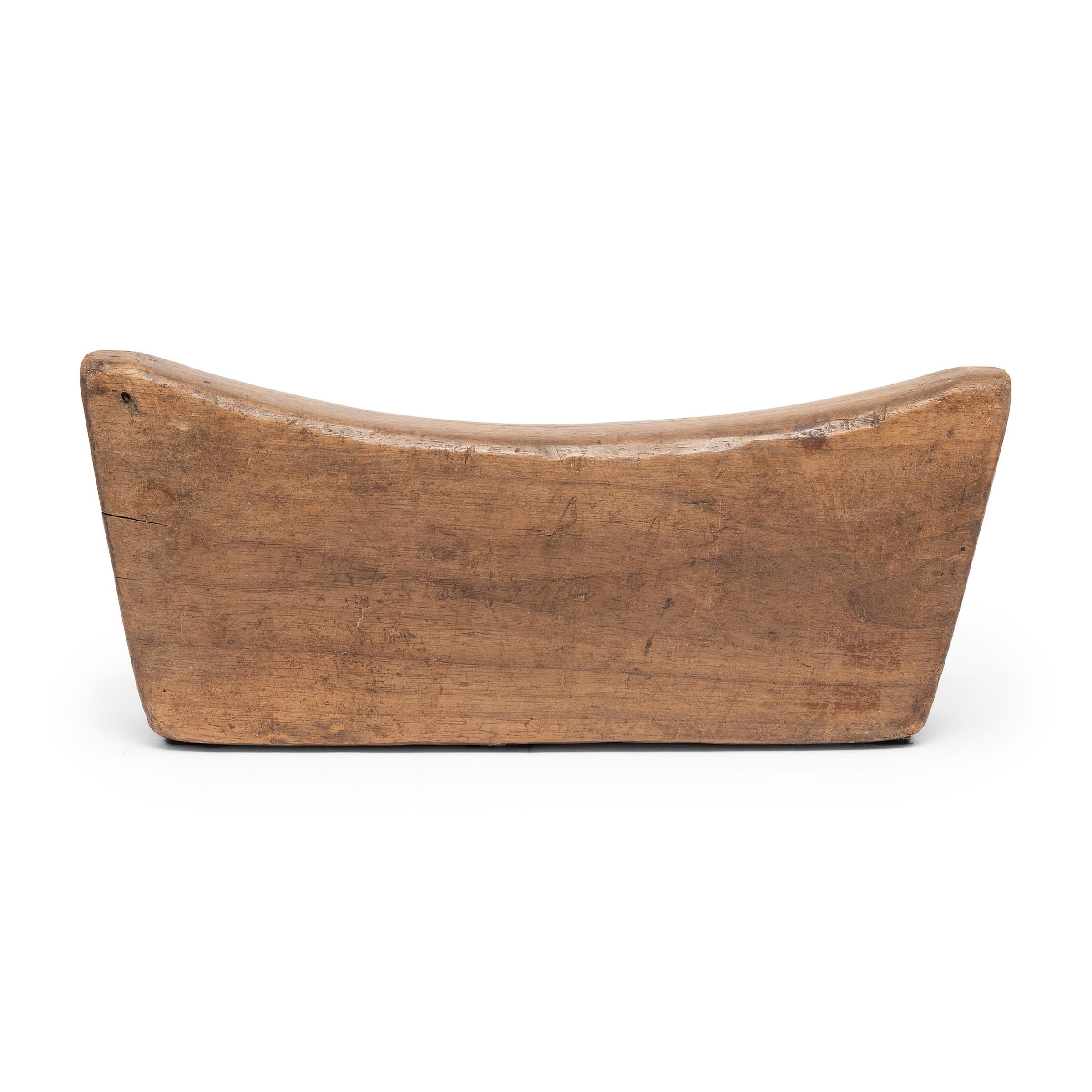 Made of Chinese northern elmwood, this smooth block of wood was once used by an upper-class woman as a headrest. The soft curve and height of the block not only supported her head and neck at rest, it also helped to preserve her intricate hairstyle.