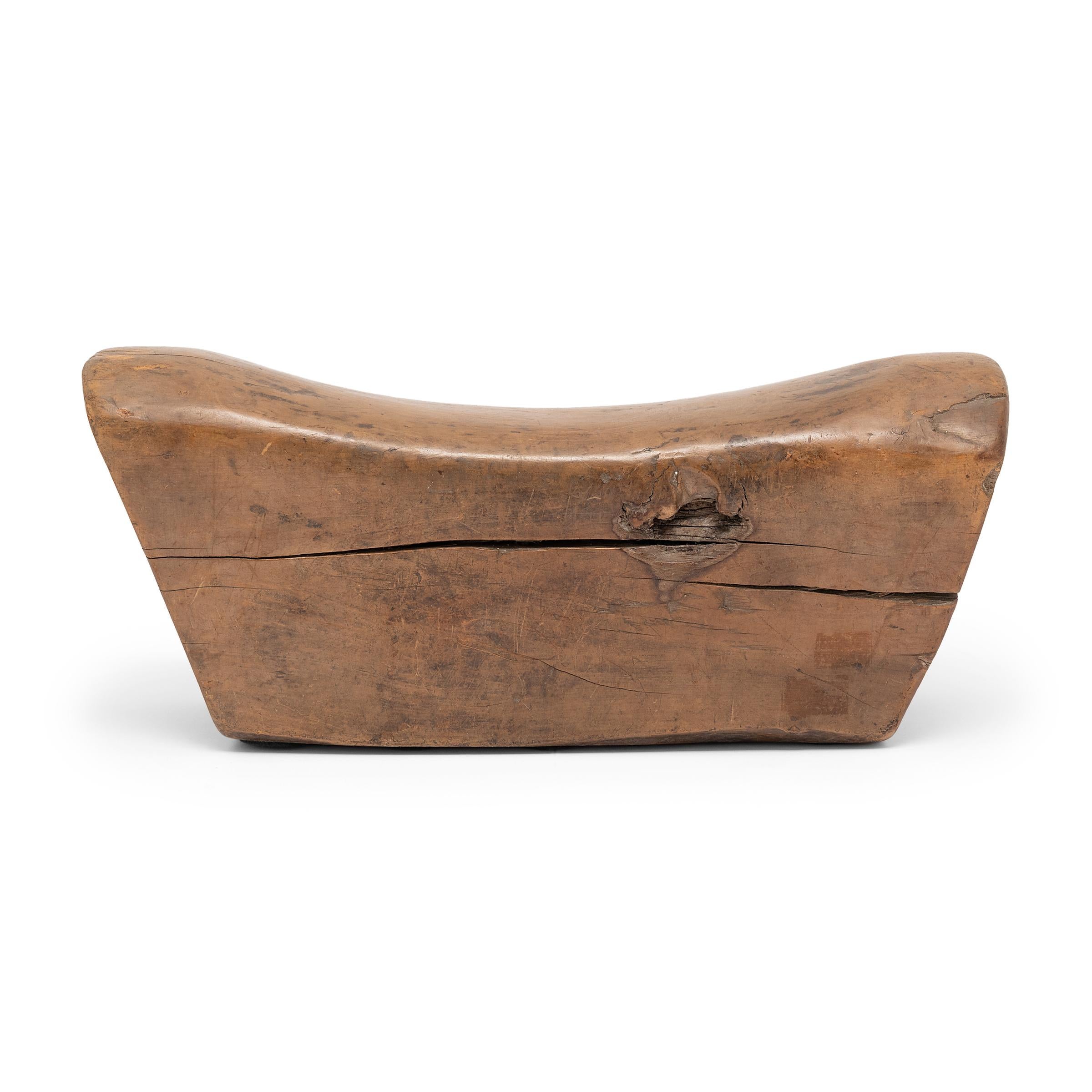 Made of Chinese northern elmwood, this smooth block of wood was once used by an upper-class woman as a headrest. The soft curve and height of the block not only supported her head and neck at rest, it also helped to preserve her intricate hairstyle.