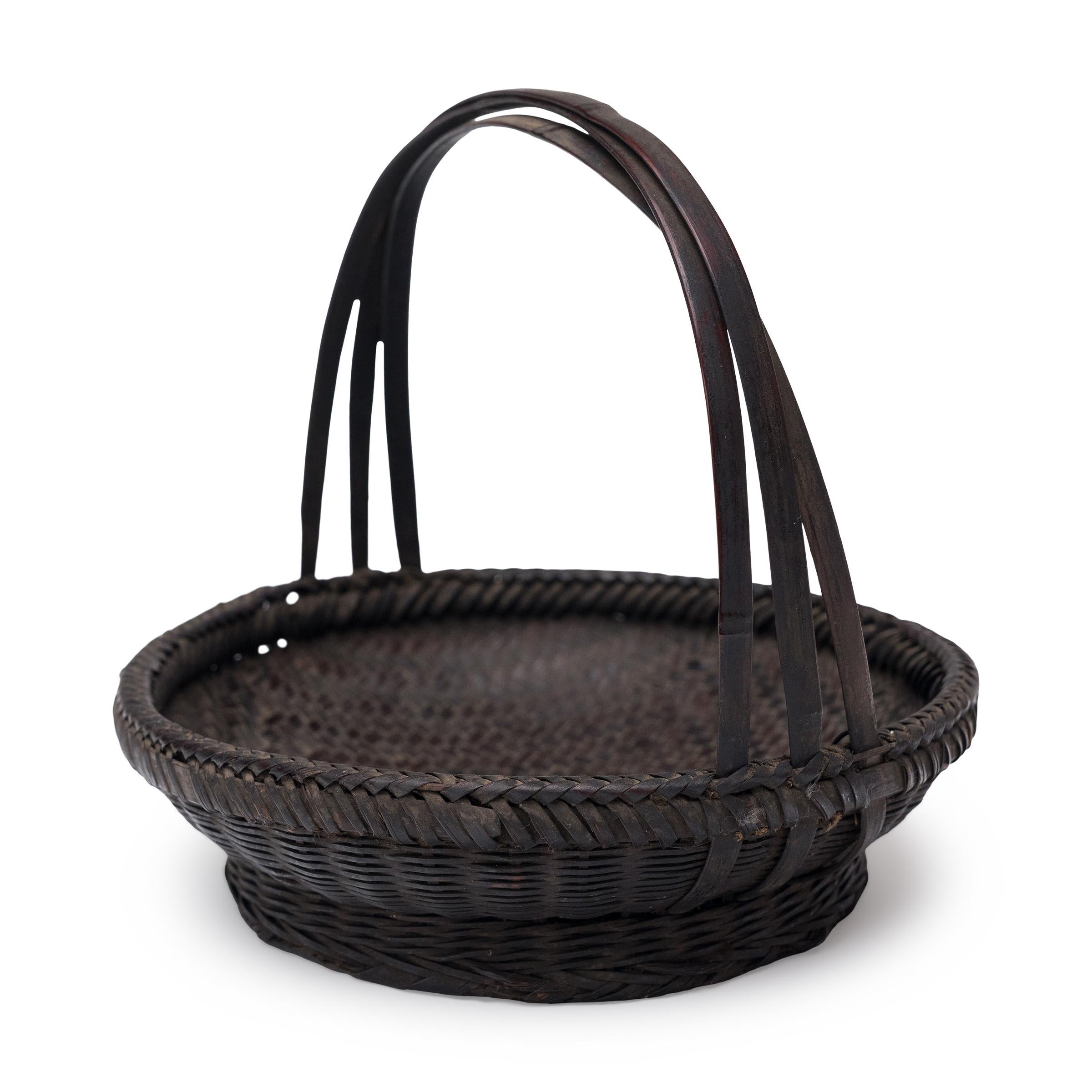 Tejida con preciosa escama y delicado arte, esta pequeña cesta de flores de principios del siglo XX es un precioso ejemplo de la cestería tradicional china. La cesta está tejida con finas tiras de bambú lacado, con un cuerpo redondo y poco profundo