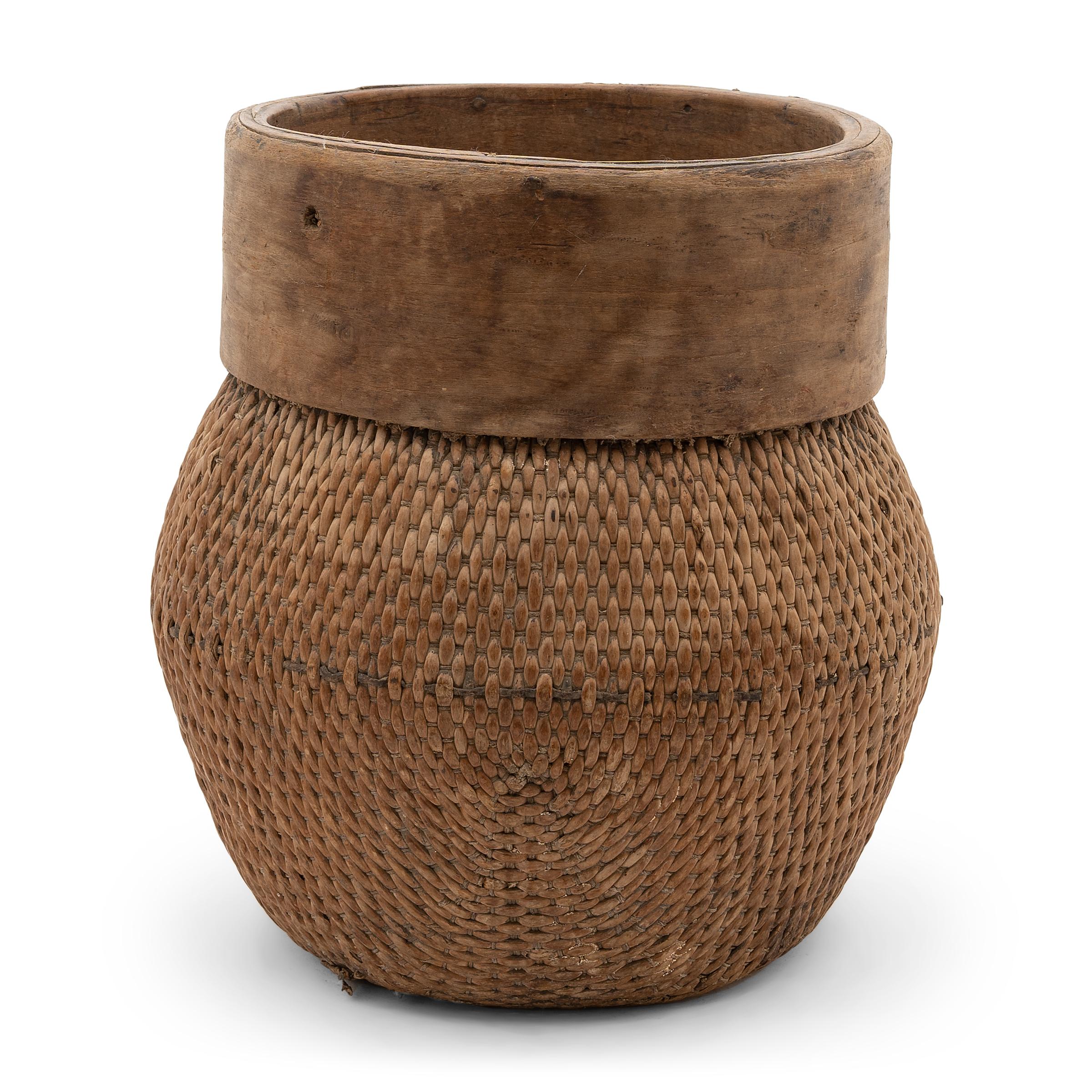 Centuries ago, a woven reed fisherman’s basket such as this would have been common in rural China as an everyday item, used until it became worn through. This particular example remains in beautiful condition, with a soft brown color and slightly