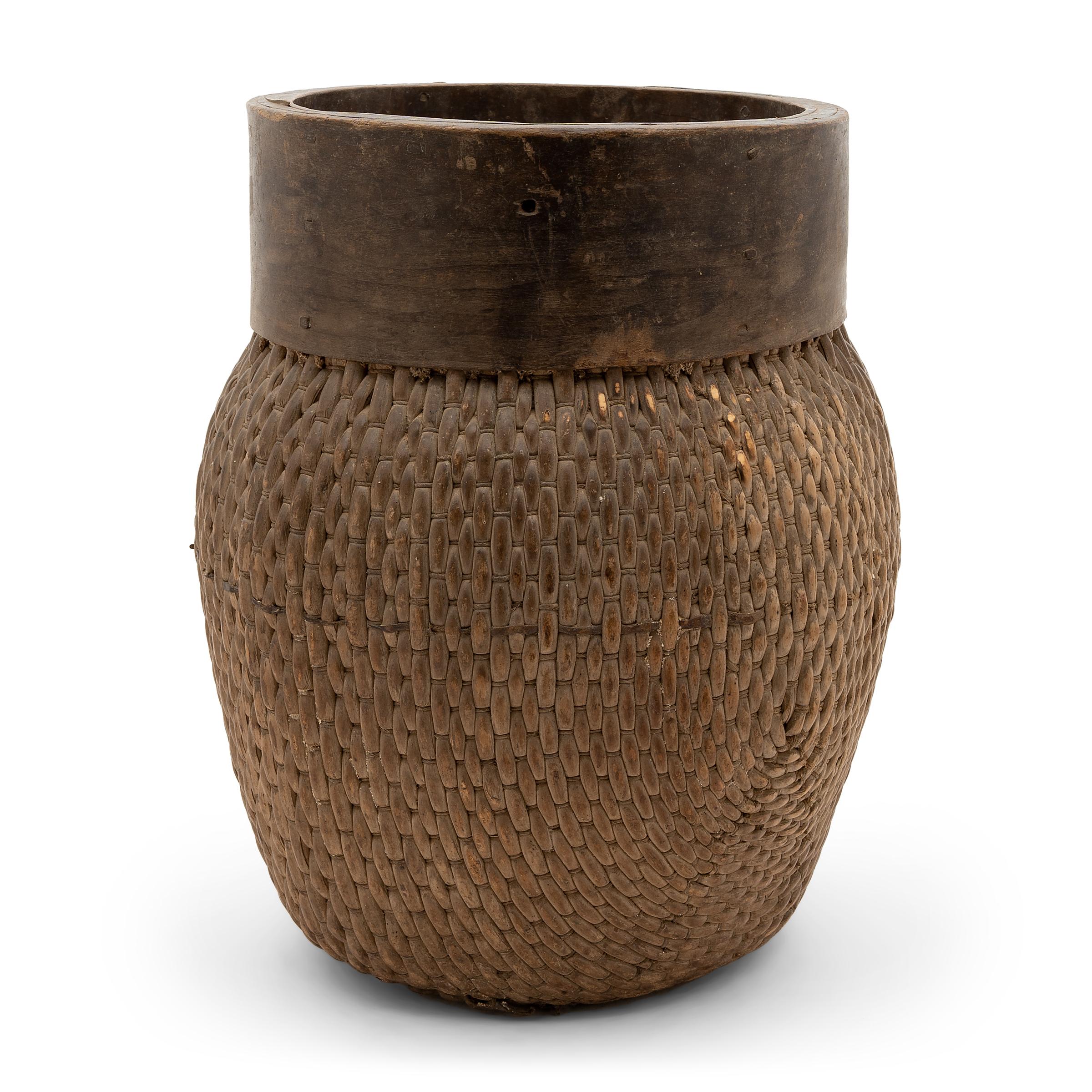 Centuries ago, a woven reed fisherman’s basket such as this would have been common in rural China as an everyday item, used until it became worn through. This particular example remains in beautiful condition with a dark brown color and slightly