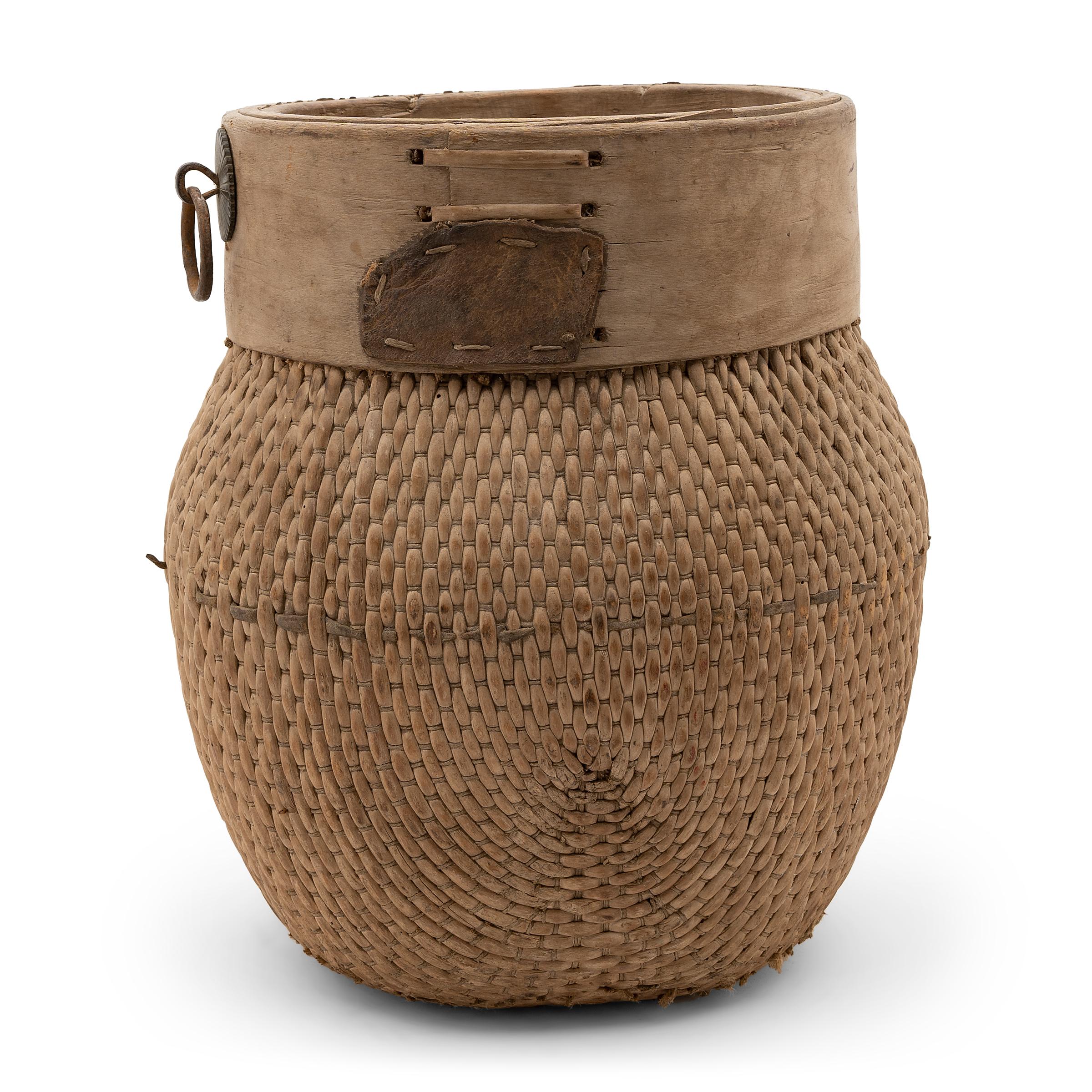 Centuries ago, a woven reed fisherman’s basket such as this would have been common in rural China as an everyday item, used until it became worn through. This particular example remains in beautiful condition with a light brown color and slightly