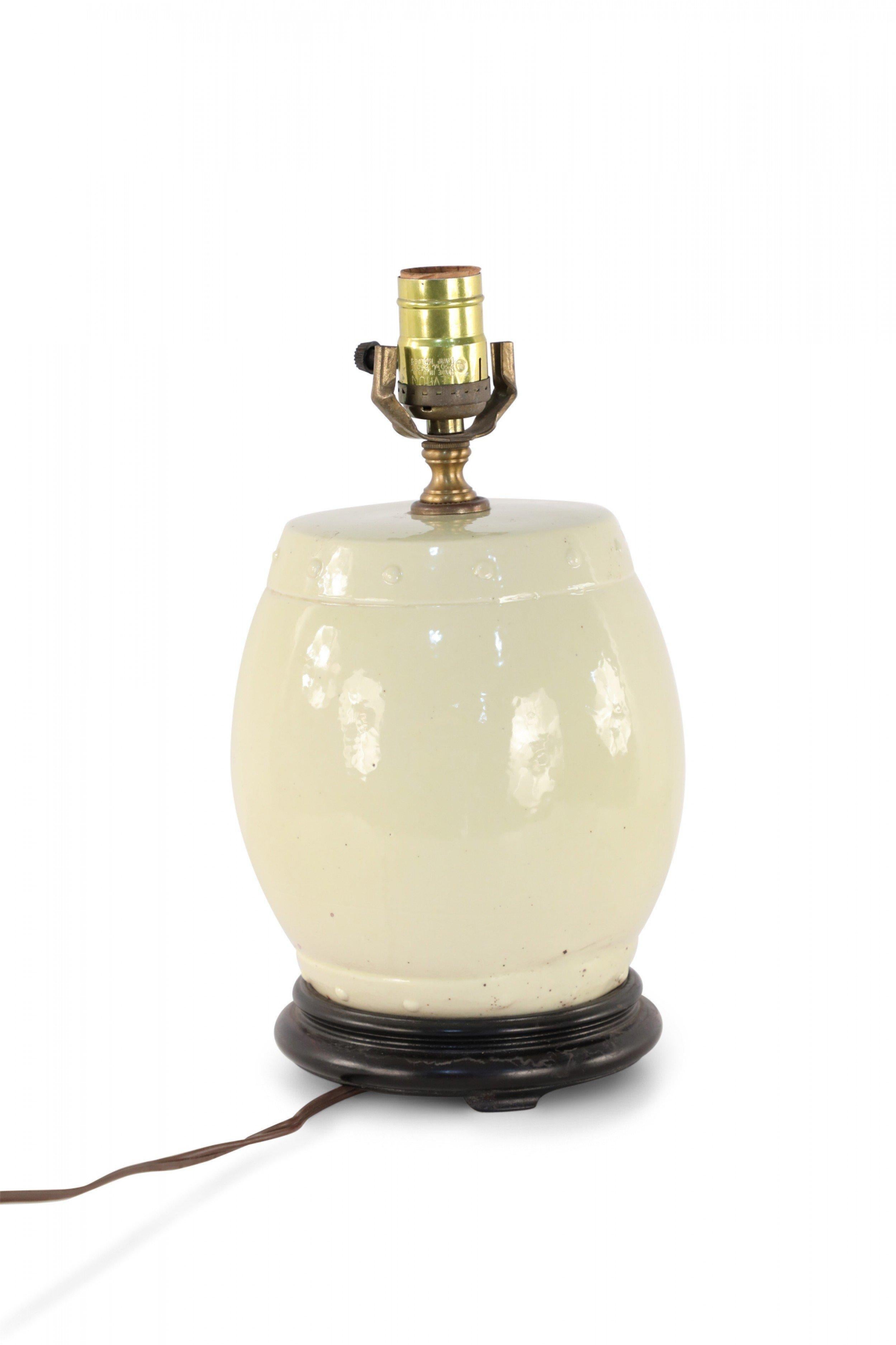 Chinese porcelain table lamp in a pale yellow hue and barrel shape on a wooden base with brass hardware. (Available in gray: NWL2002).
  