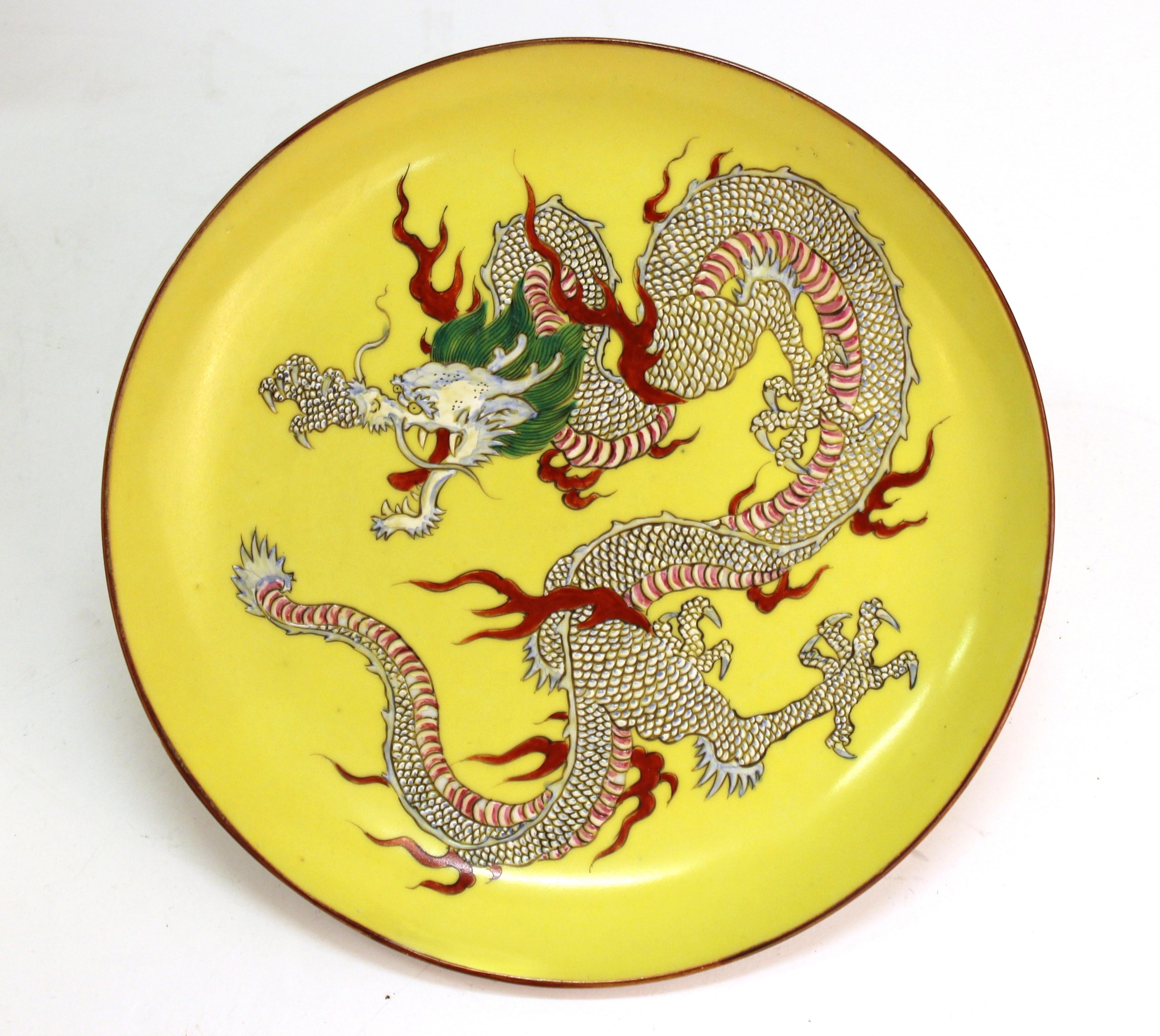Chinese yellow porcelain decorative charger depicting a hand painted five-clawed dragon. The piece was made in China during the 1890s-1900s and is in great vintage condition with age-appropriate wear.