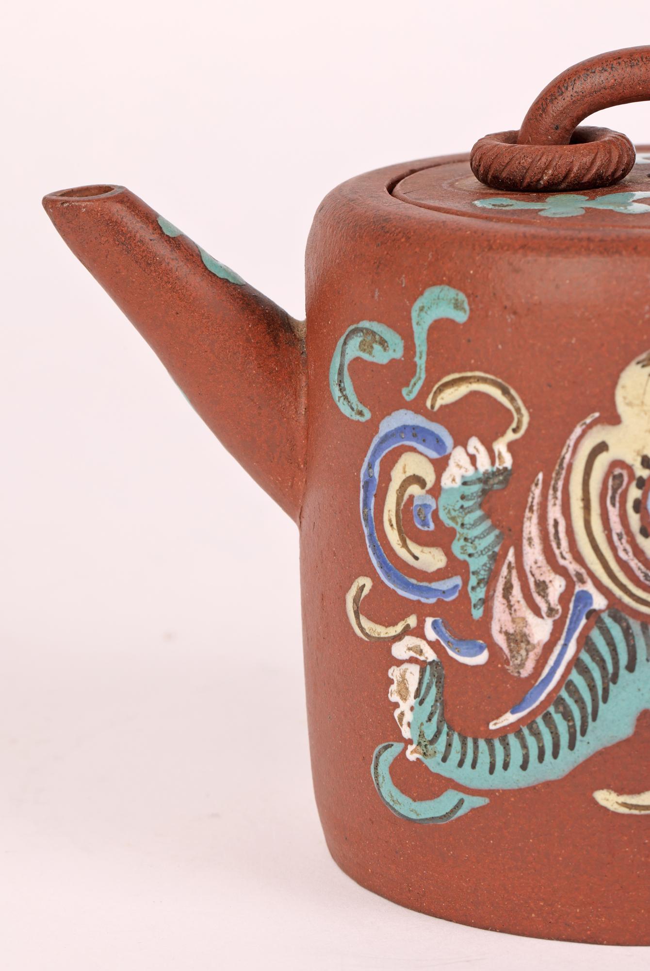 A very fine antique Chinese Yixing teapot decorated in the famille verte palette with a lion dog and precious object dating from the 18th or early 19th century. 

These unglazed teapots are considered to brew the best tea by the Chinese.

The