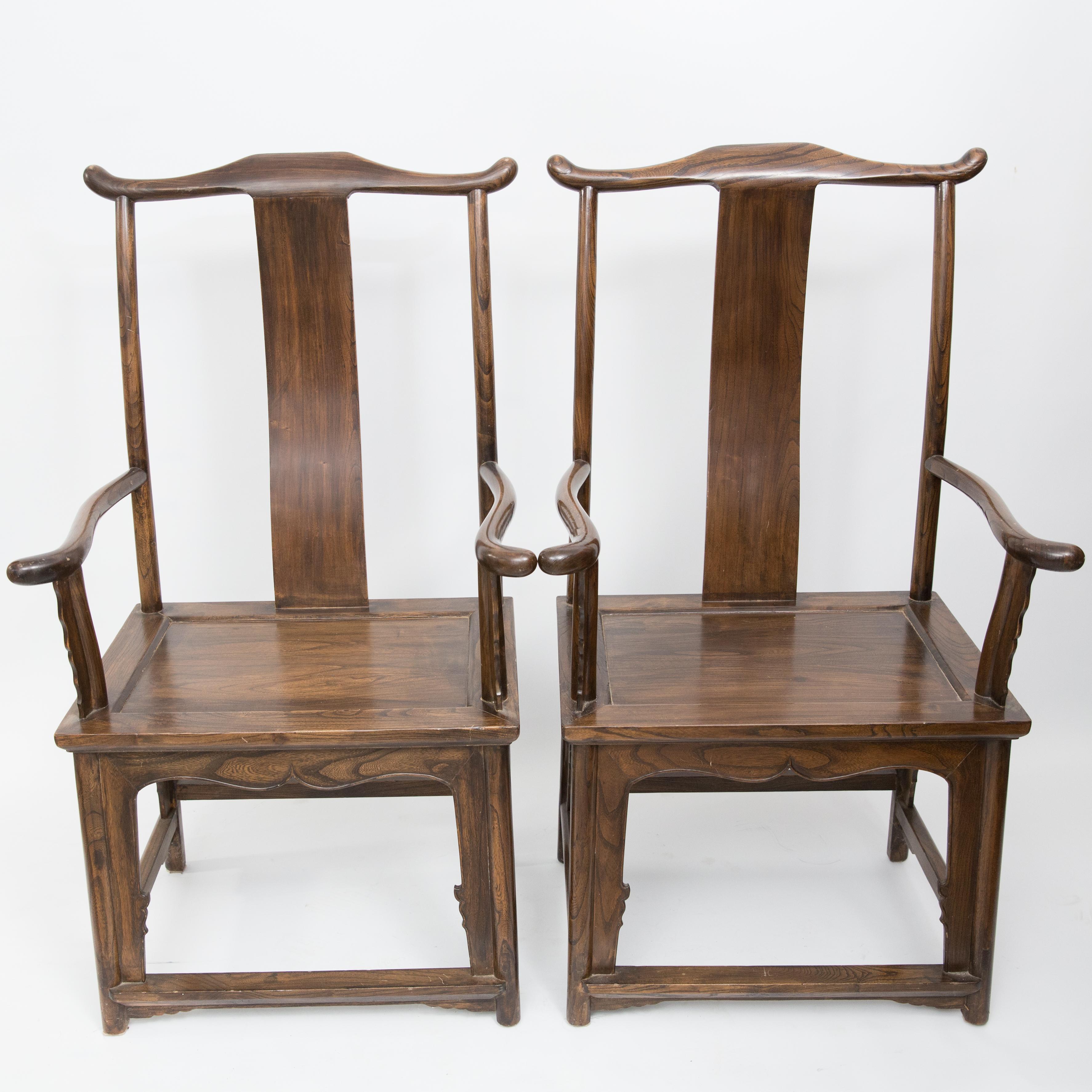 Offered is a graceful pair of yolk high back exotic wood Chinese antique arm chairs in the Classic Ming design. The chairs could be used as side chairs or dining chairs. There is no structural damages on the chairs and they are structurally sound