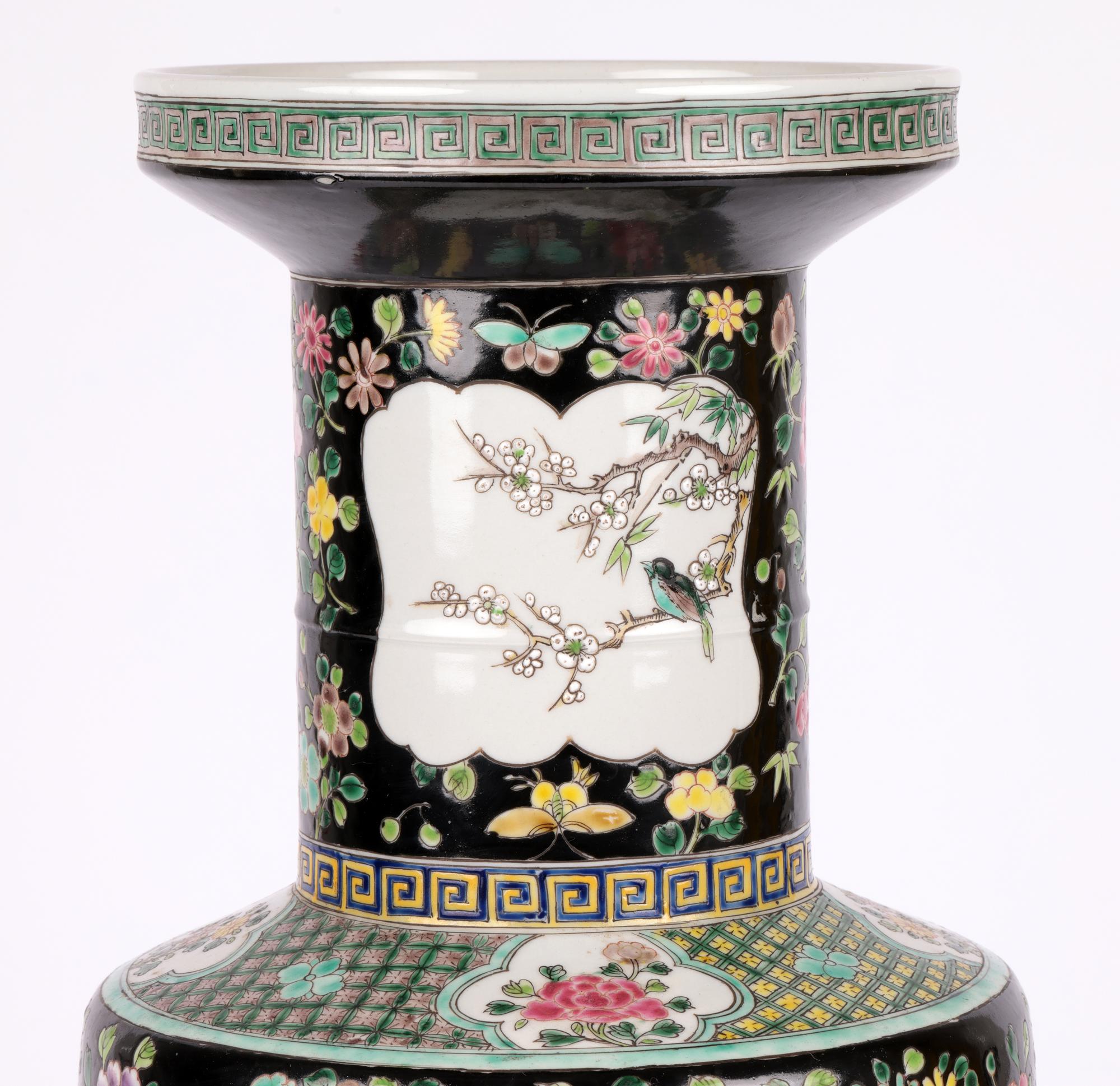 A large and impressive Chinese famille noir porcelain vase hand painted with decorative panels with birds, animals and scholars objects dating from the early to mid-20th century. The tall rouleau shaped vase stands on a narrow round unglazed foot