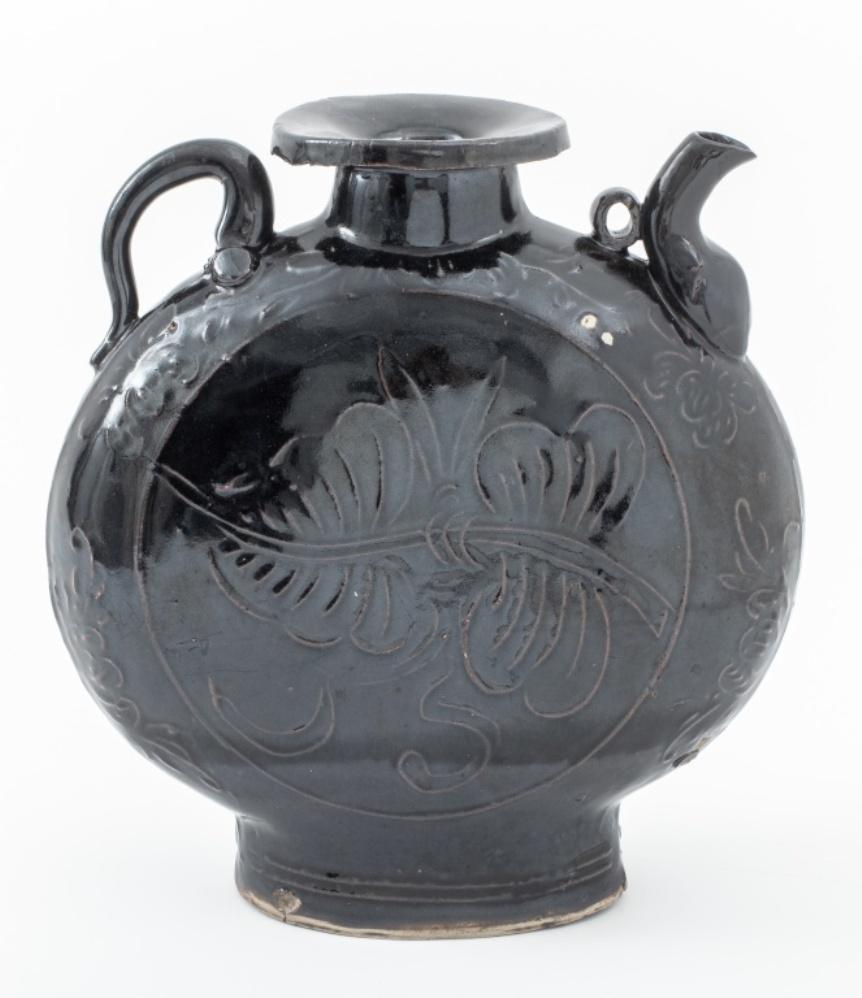 Chinese Yuan dynasty Cizhou black-glazed moon ewer, of typical form with arm and spout and incised decoration. 11