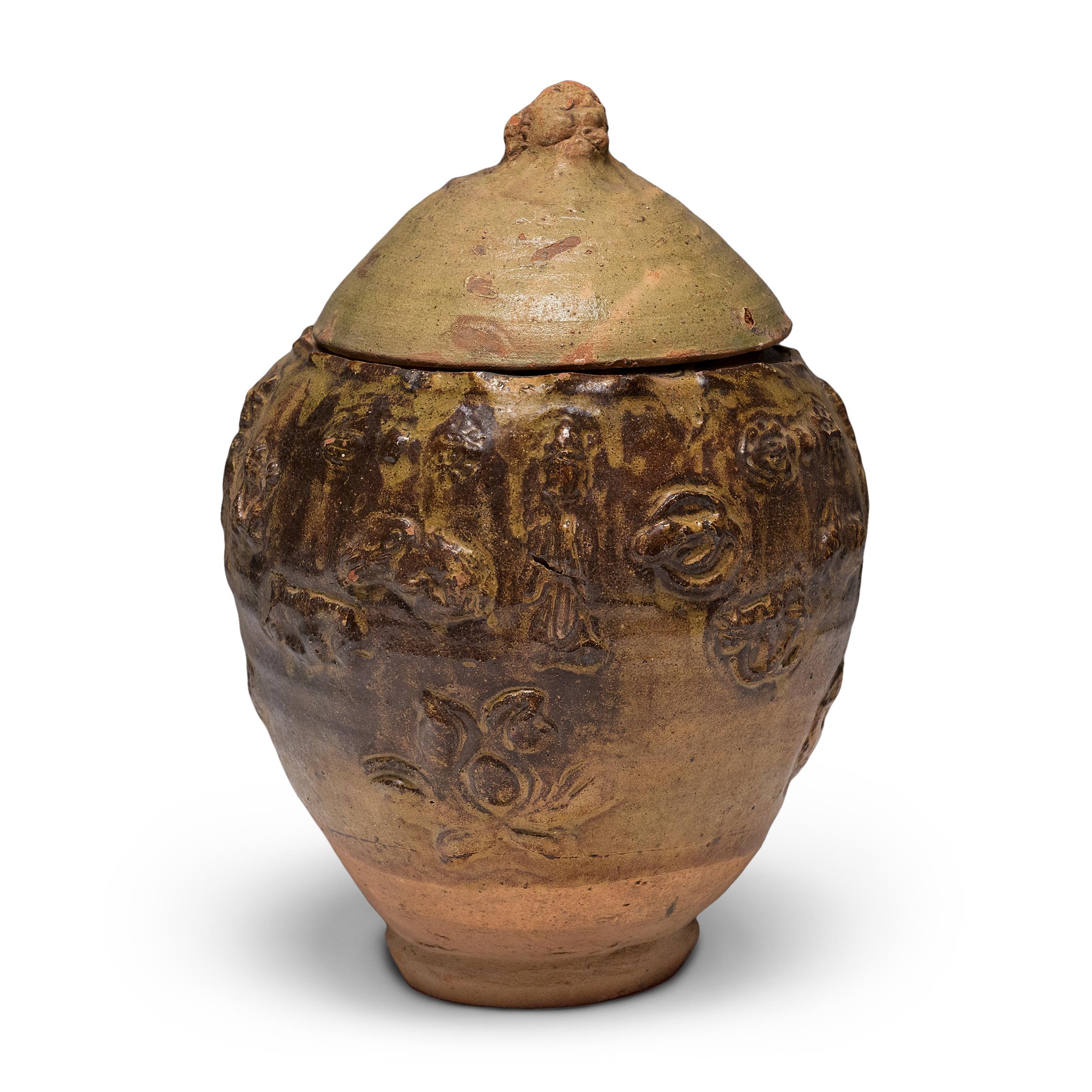 Hermosa en su imperfección, esta jarra con tapa de la provincia de Yunnan es un recipiente de ofrendas, o jarra espiritual, que originalmente se llenaba con ofrendas rituales como monedas, conchas, flores y granos. Atribuida a la dinastía Yuan