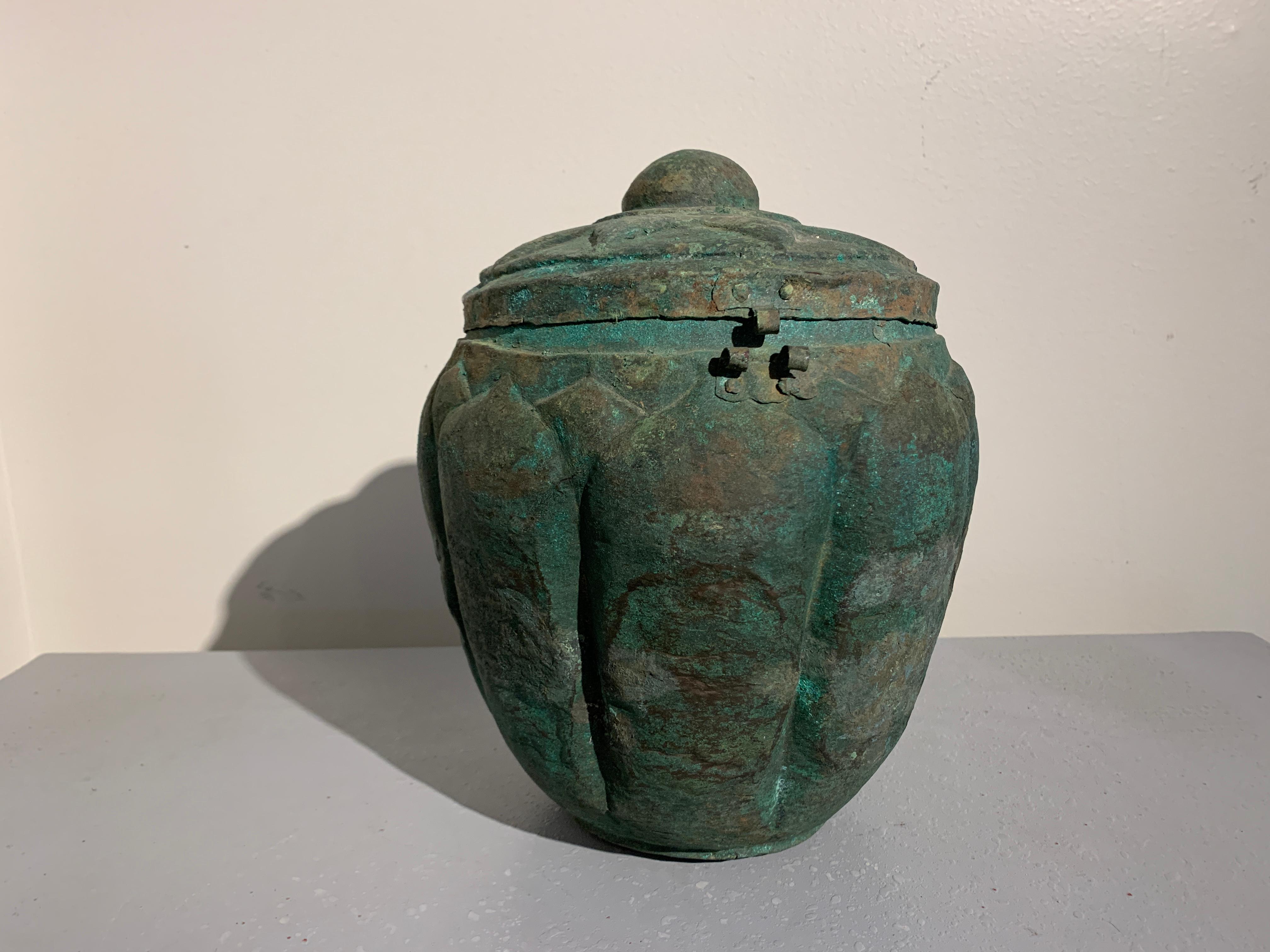 A rare Chinese repousse bronze (copper alloy) lotus jar, Yuan Dynasty (1270-1368), Yunnan, China.

The offering vessel of globular form, with a wide, rounded body and a hinged lid. The body of the jar decorated with a series of large and bold