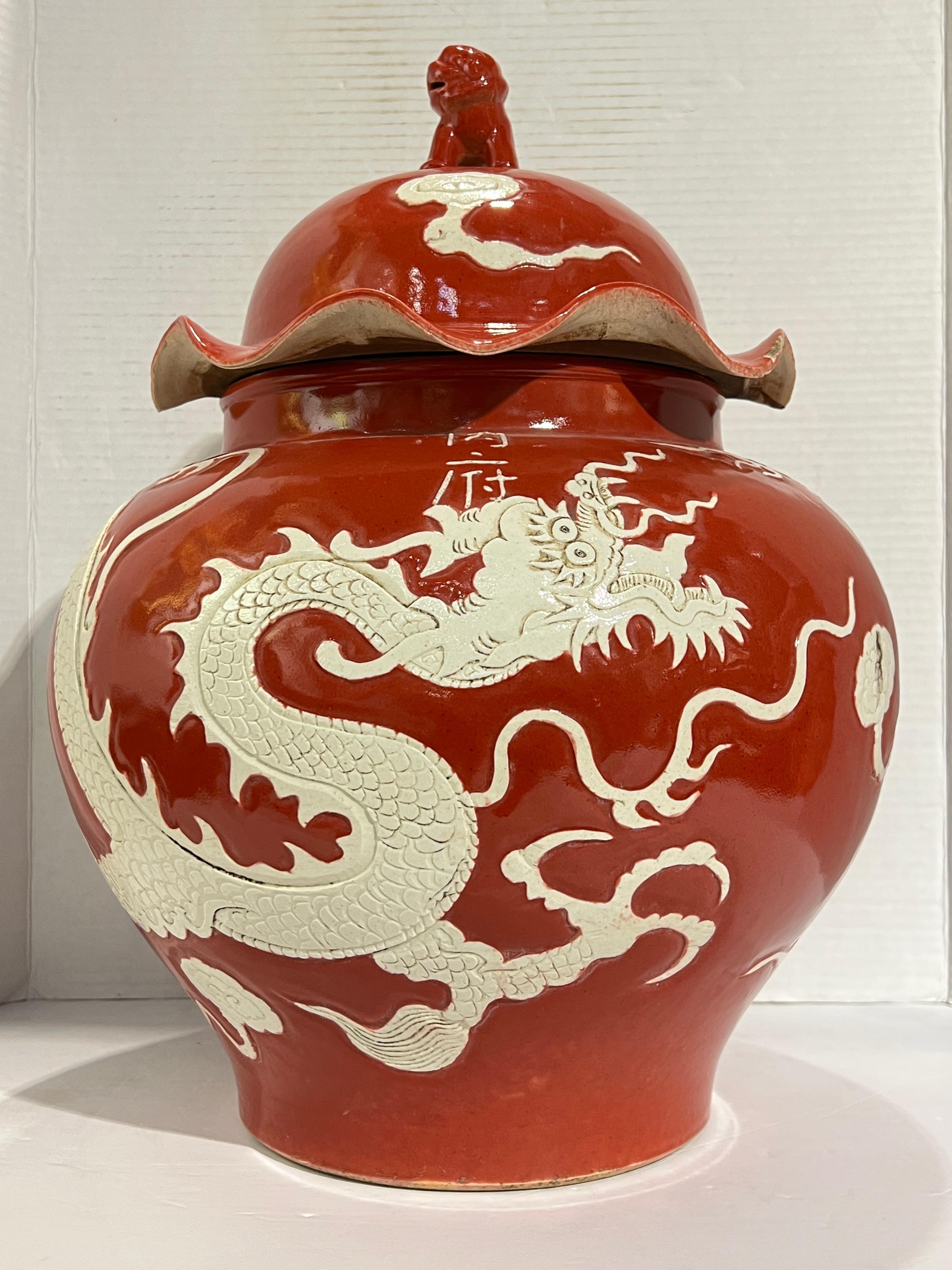 Gran jarra antigua (siglo XIX) (olla con tapa) de estilo dinastía Yuan con  diseños en relieve de un dragón sobre fondo rojo vidriado, que se distingue por su gran tamaño (17 por 13 pulgadas) y tapa con remate de león foo. Firmado 内宫 ( Nei gong,