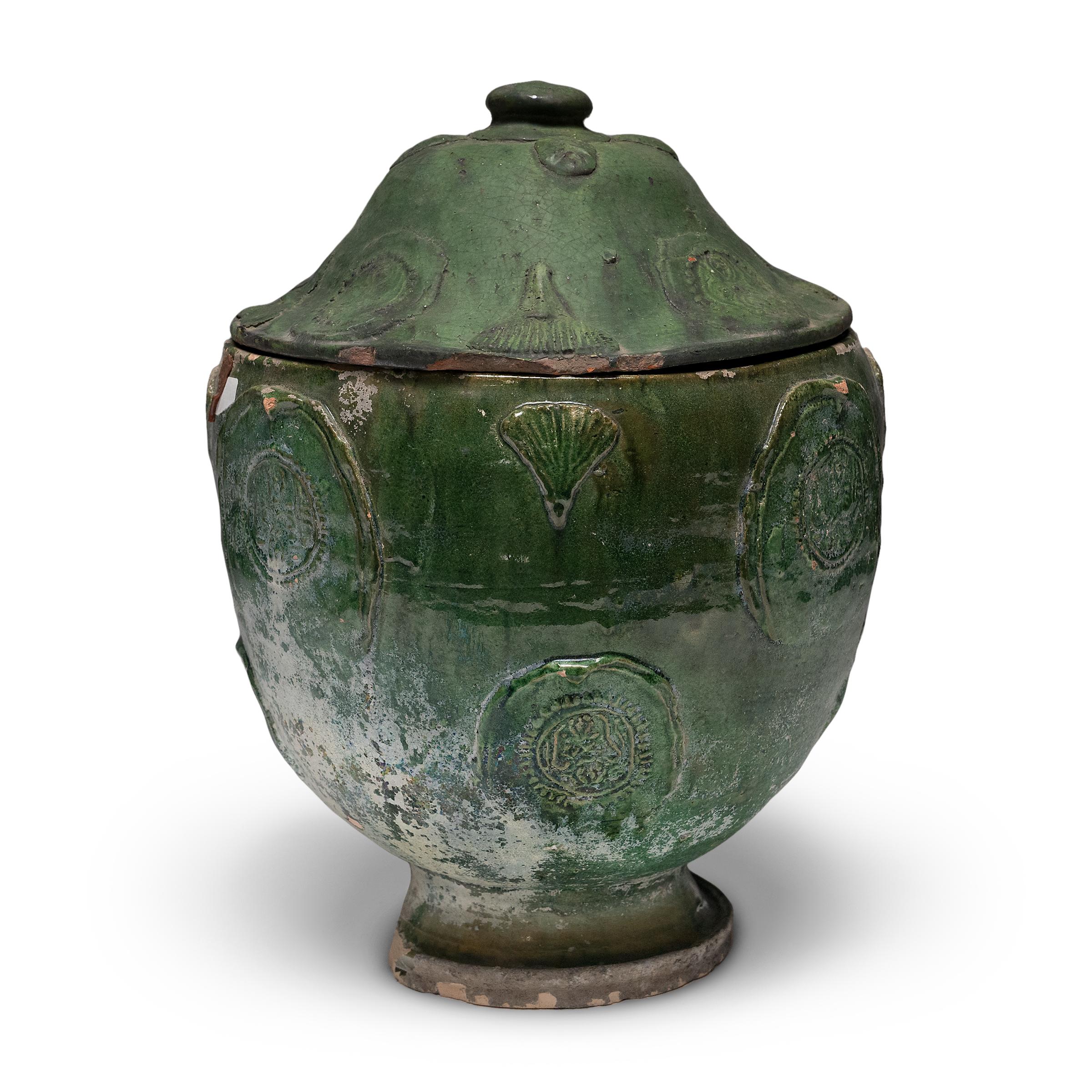 Belle dans son imperfection, cette jarre à couvercle émaillé vert de la province du Yunnan est un récipient à offrandes, ou jarre à esprits, qui contenait à l'origine des offrandes rituelles telles que des pièces de monnaie, des coquillages, des