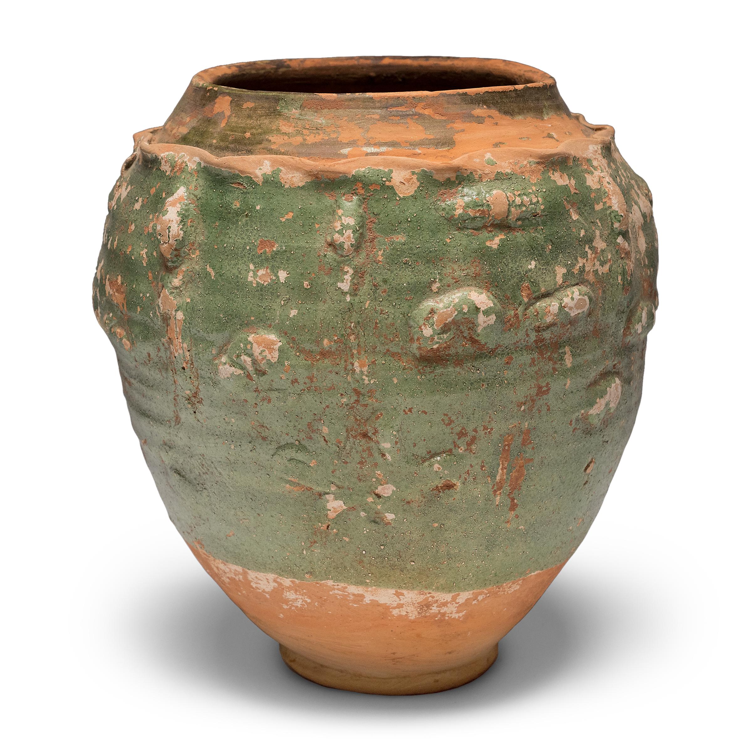 Belle dans son imperfection, cette jarre vernissée verte de la province du Yunnan est un récipient à offrandes, ou jarre à esprits, qui contenait à l'origine des offrandes rituelles telles que des pièces de monnaie, des coquillages, des fleurs et
