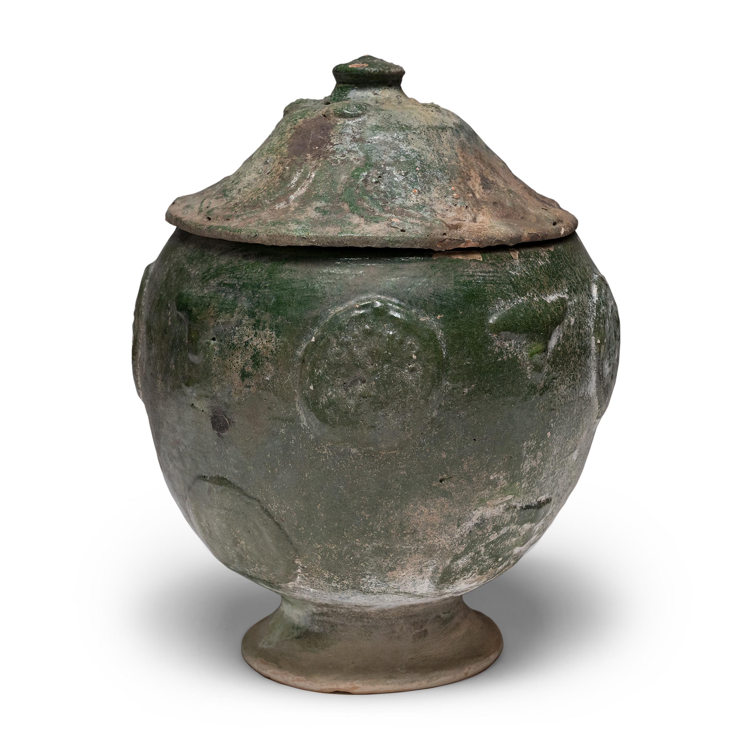 Belle dans son imperfection, cette jarre à couvercle émaillé vert de la province du Yunnan est un récipient à offrandes, ou jarre à esprits, qui contenait à l'origine des offrandes rituelles telles que des pièces de monnaie, des coquillages, des